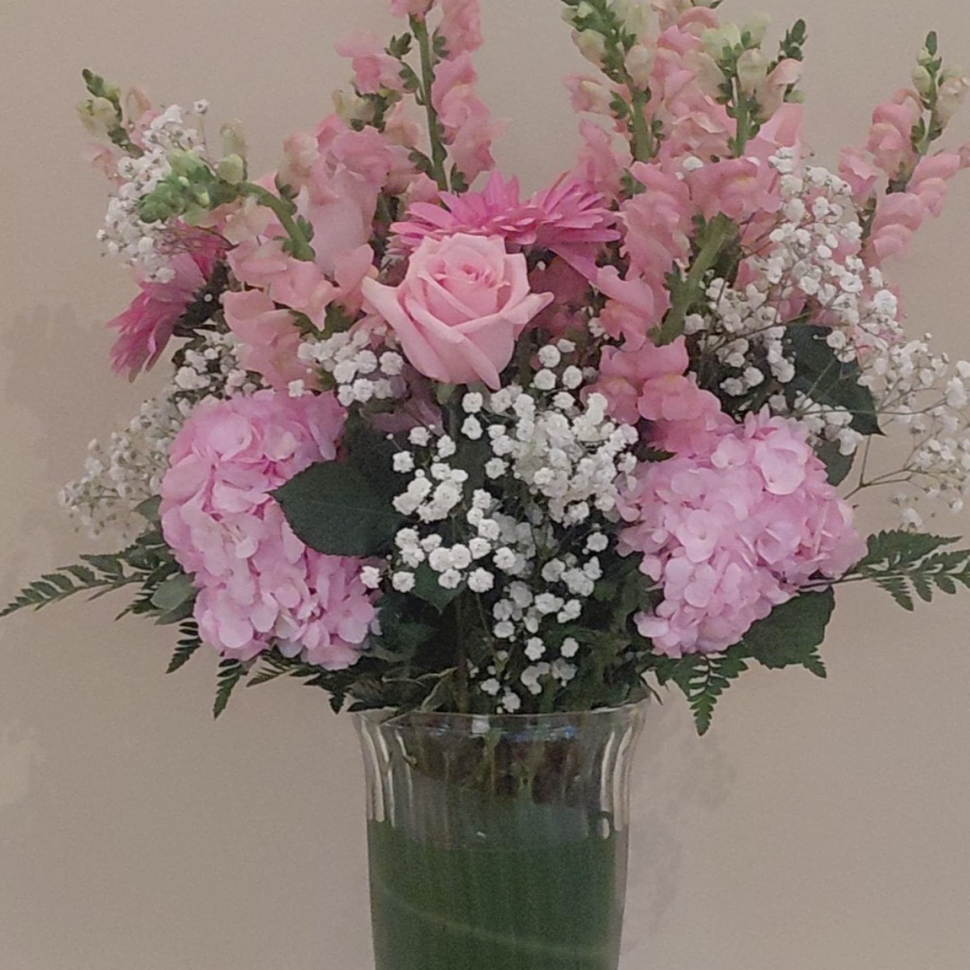 Pink mixed flower arrangement in a clear glass vase