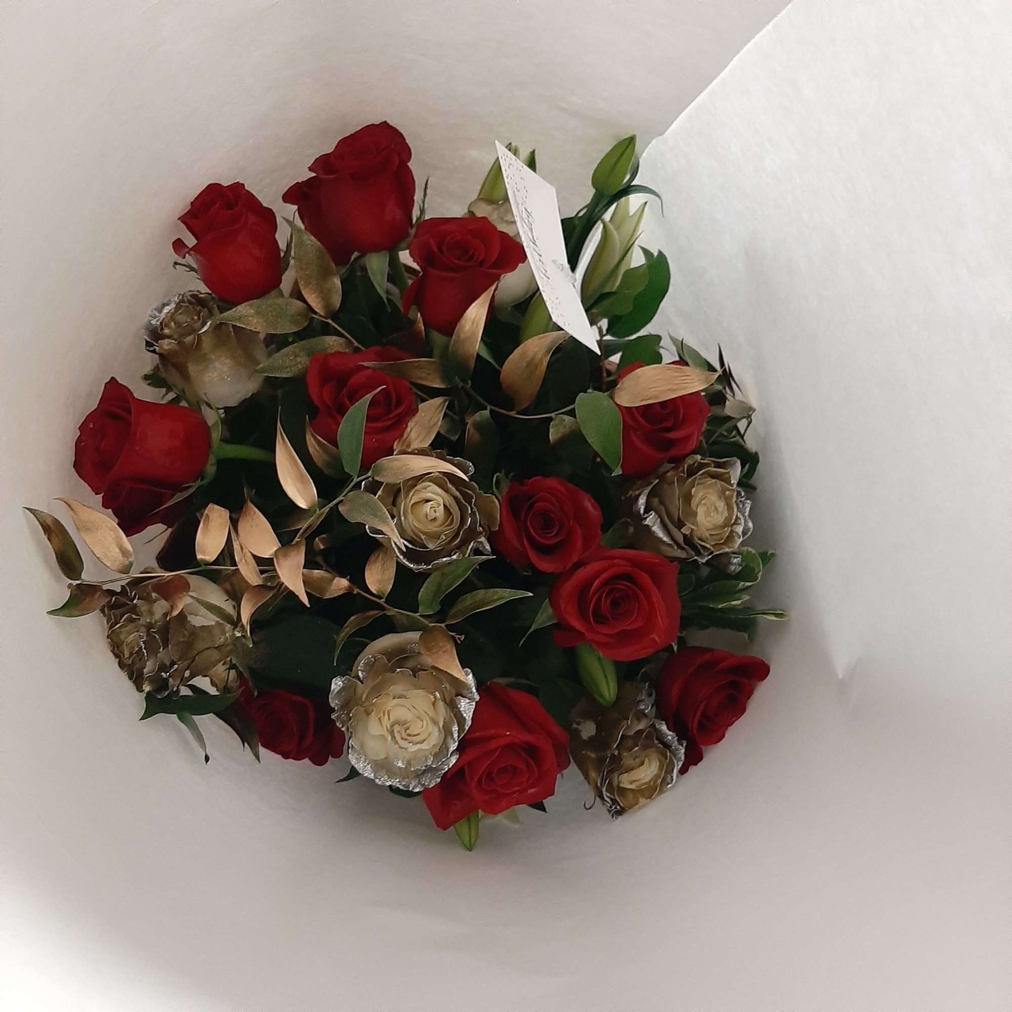 Bouquet of red and cream roses wrapped in white paper