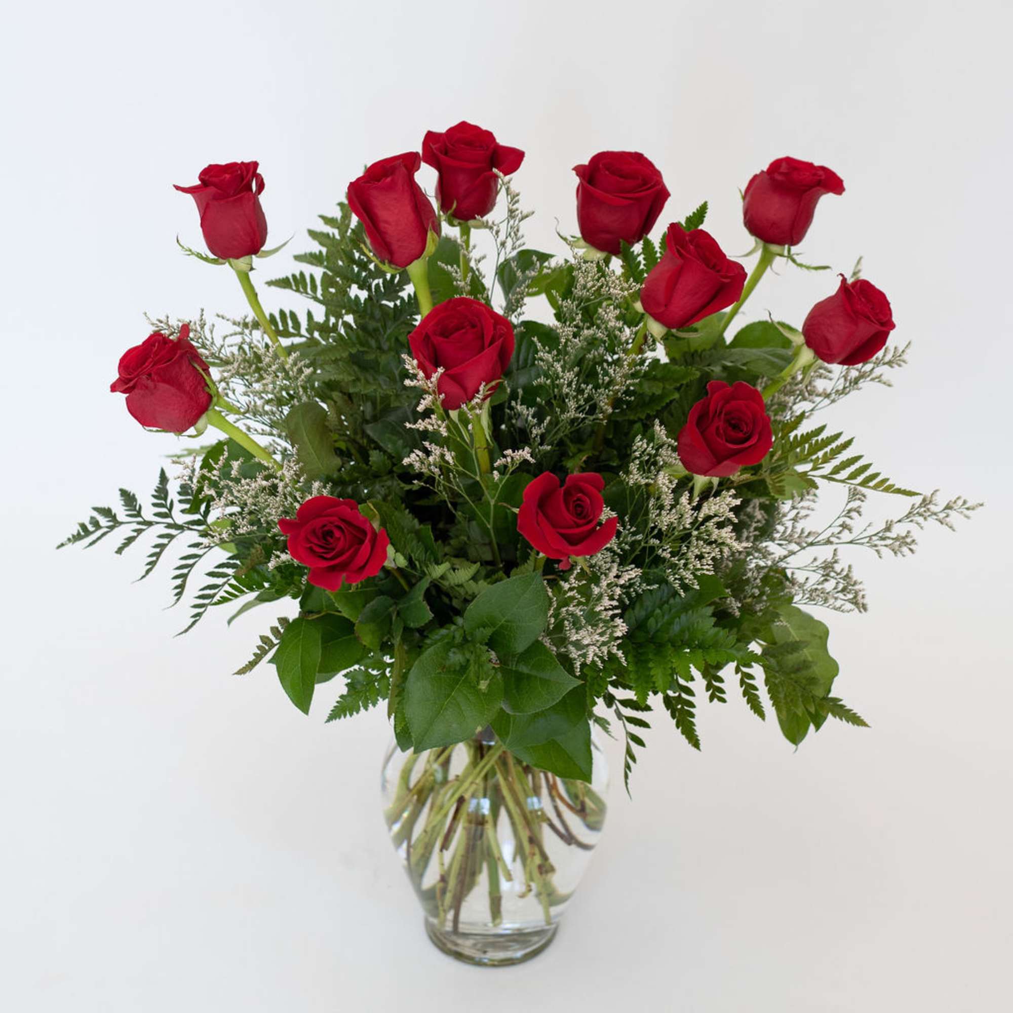 Red roses arranged in a clear glass vase