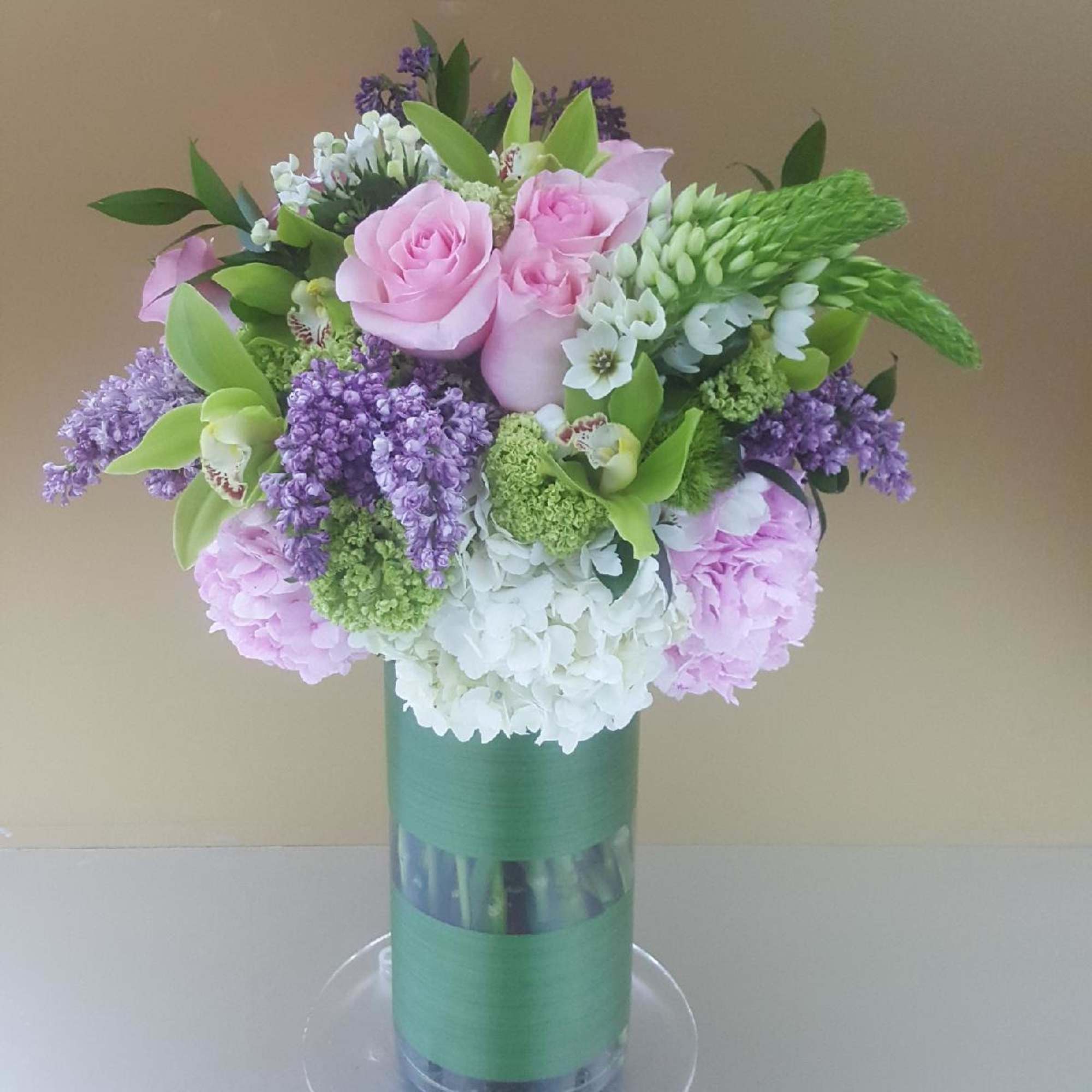 Pink roses and hydrangeas in a tall glass vase