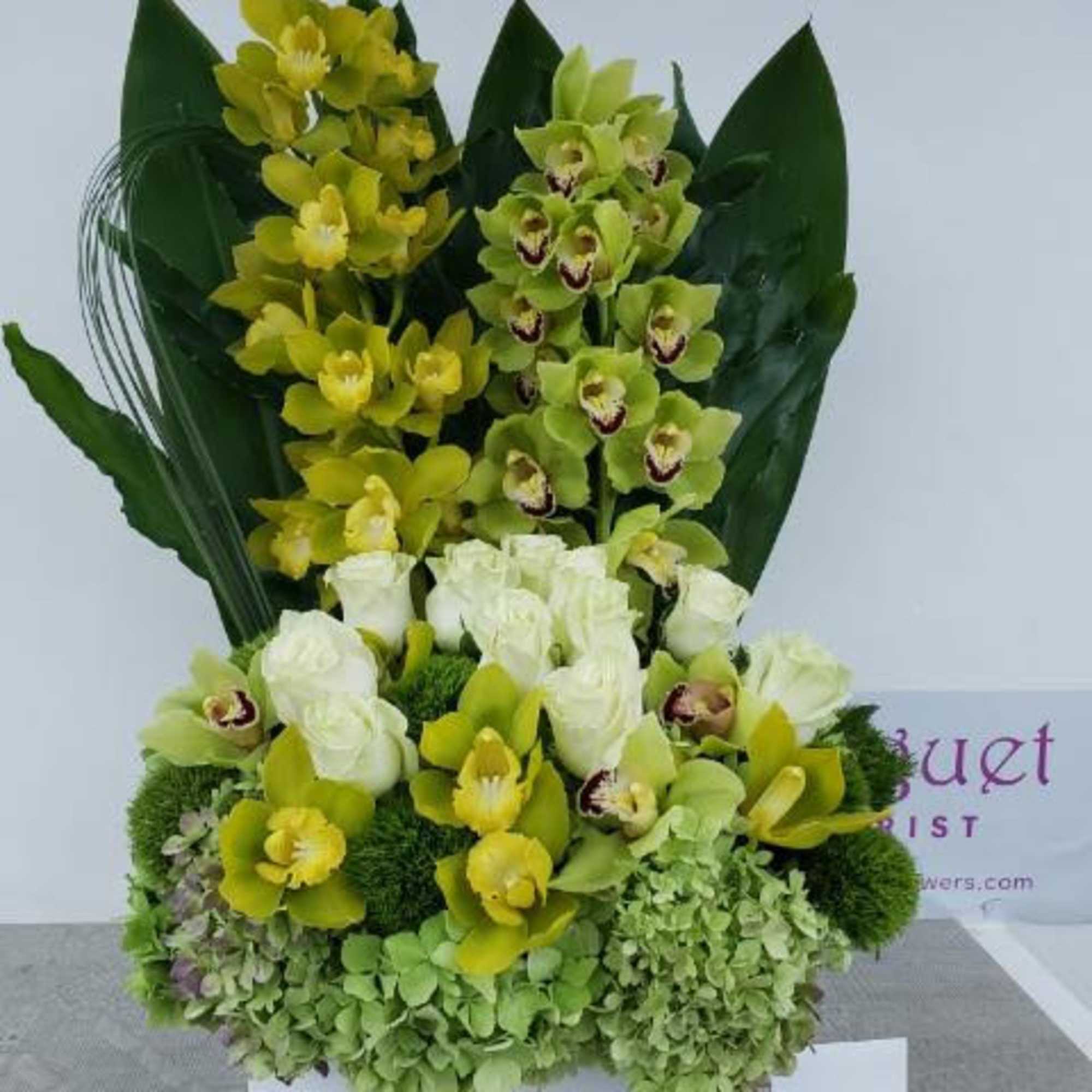 Yellow and green orchid arrangement with white roses in a box