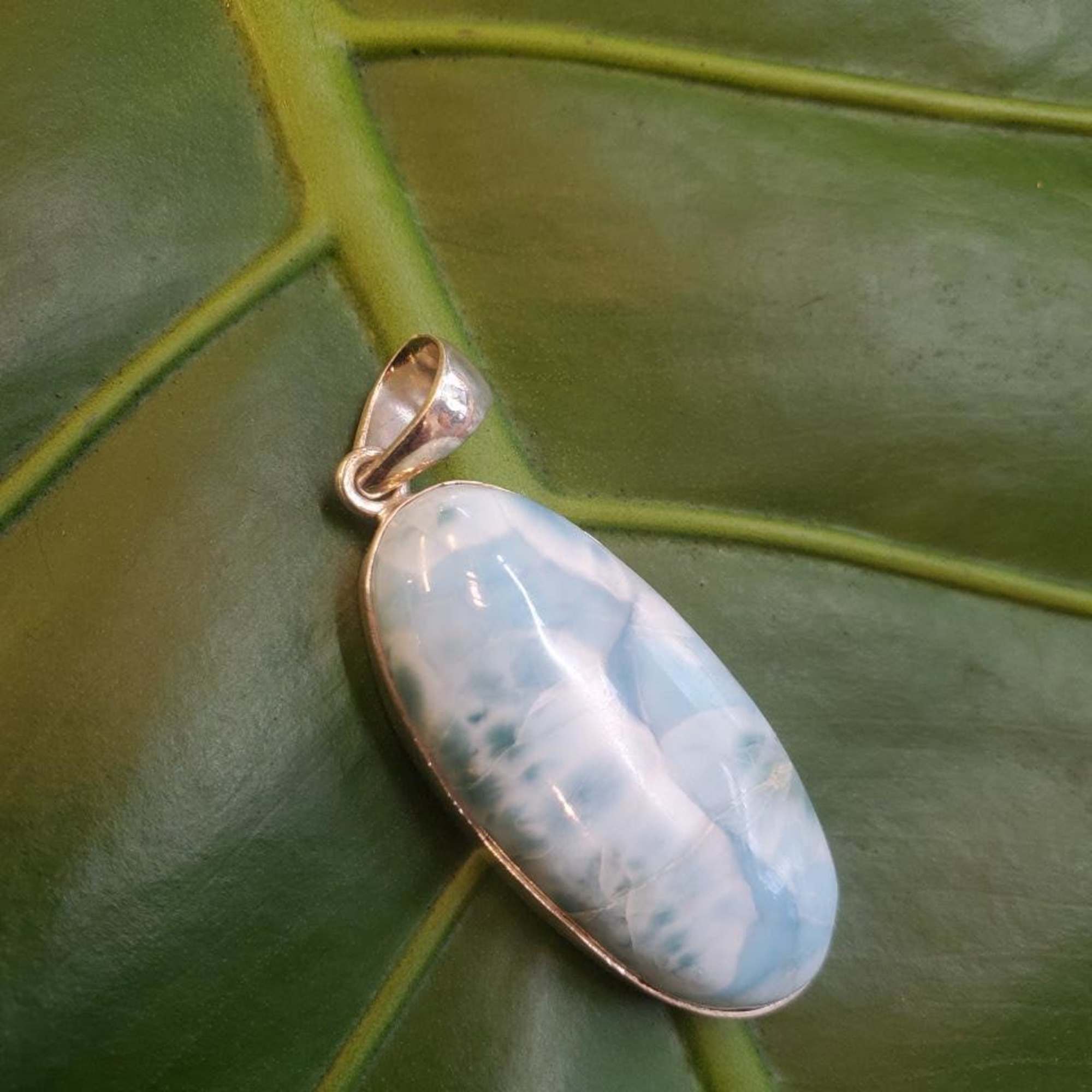 Oval blue-and-white stone pendant with a silver bail