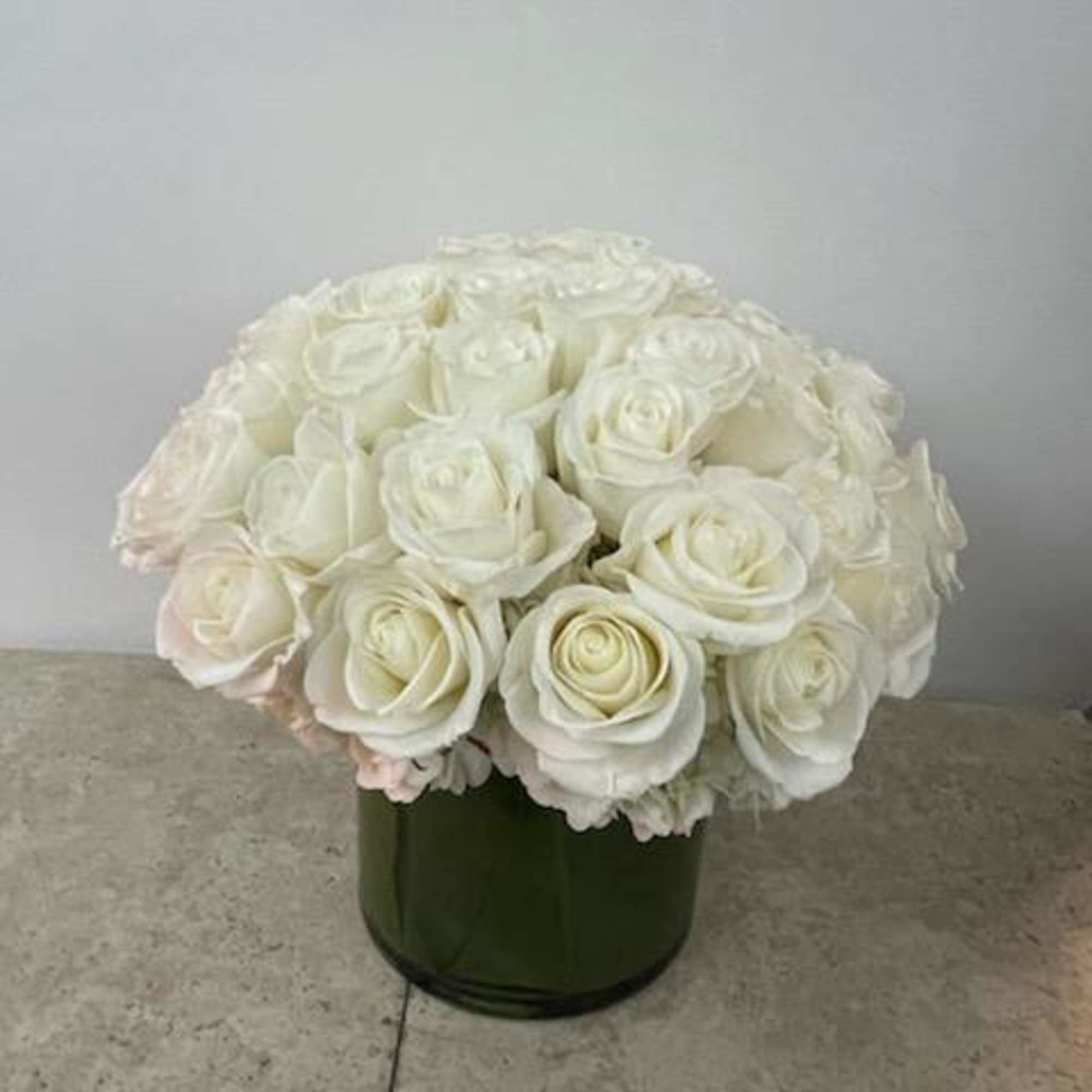 White rose bouquet in a dark green vase