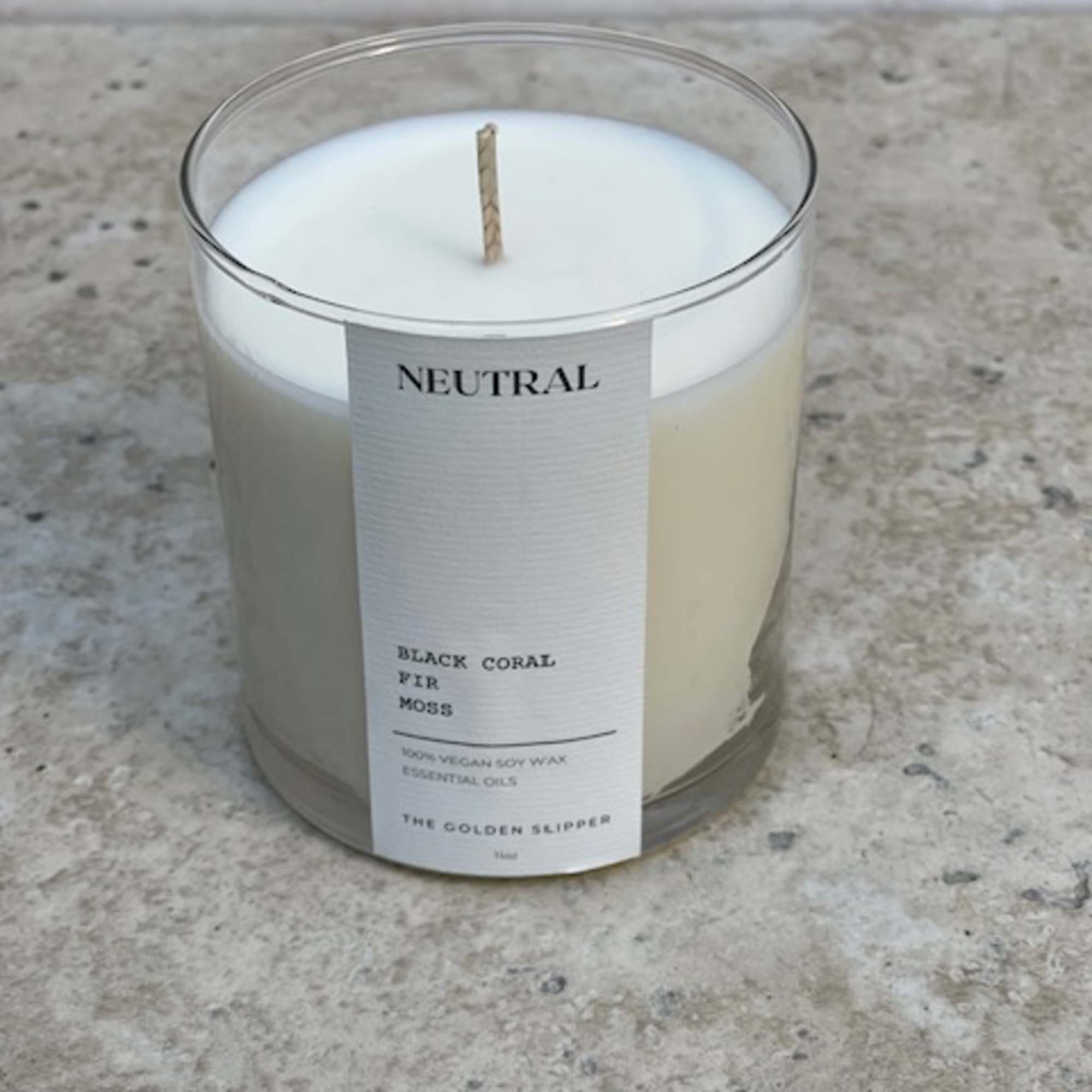 White candle in a clear glass jar with a label
