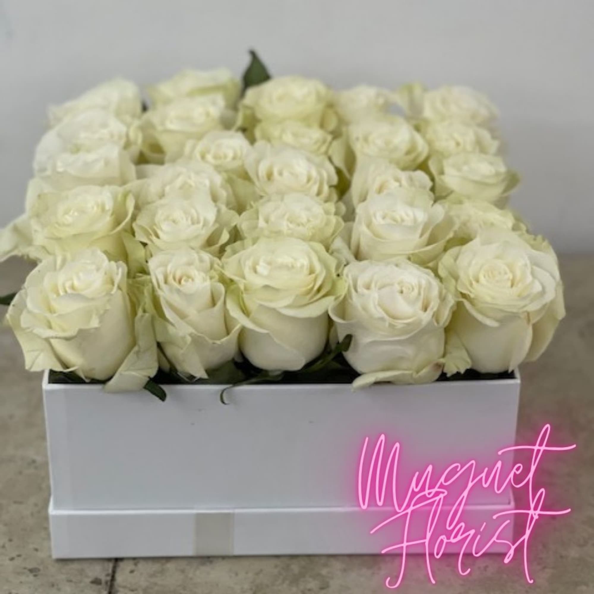 Box of white roses arranged tightly in a white container