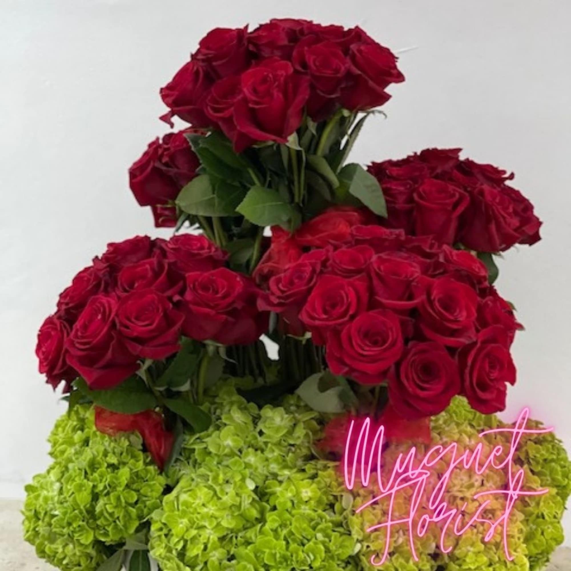 Tiered bouquet of red roses with green hydrangeas at the base