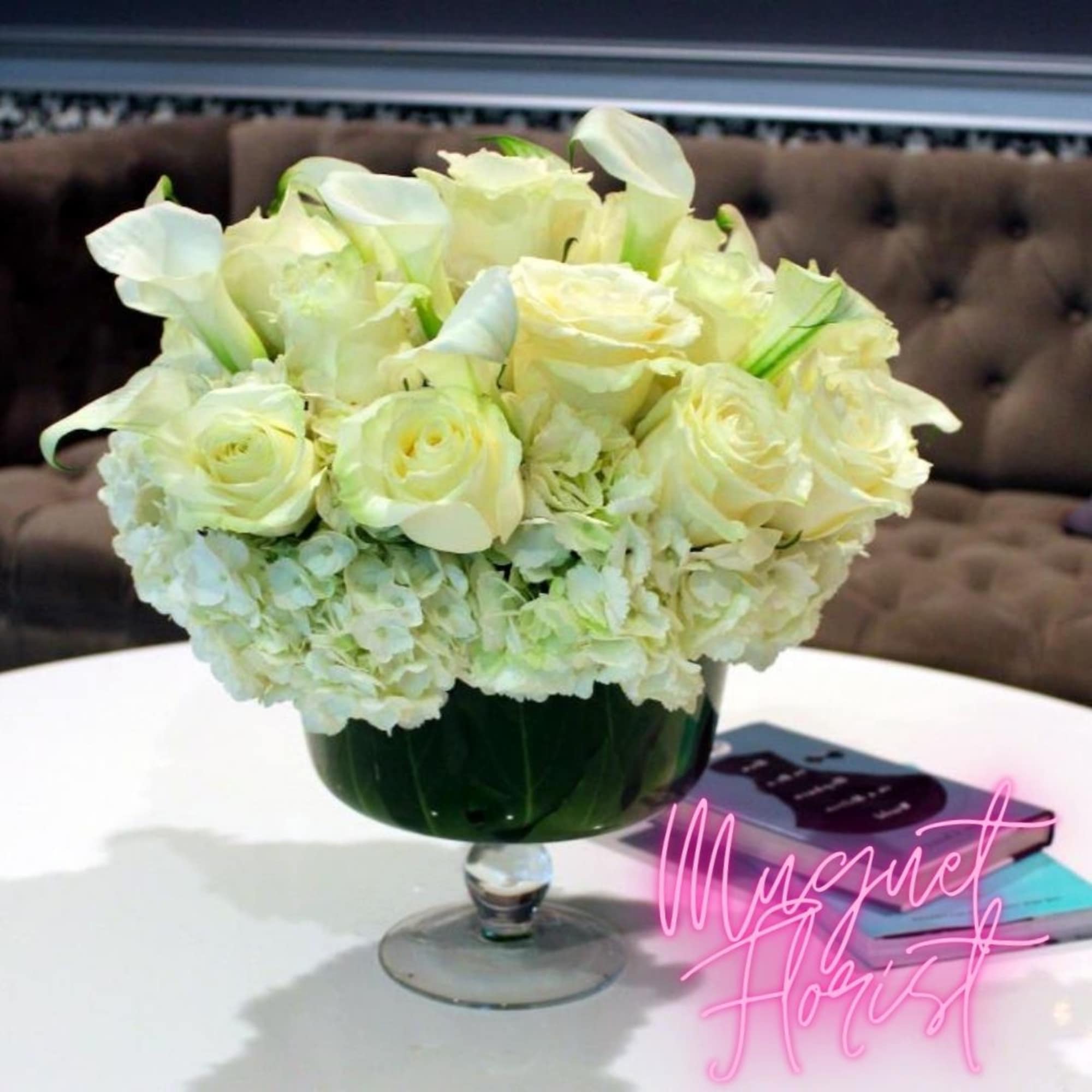 White roses and calla lilies in a green glass vase