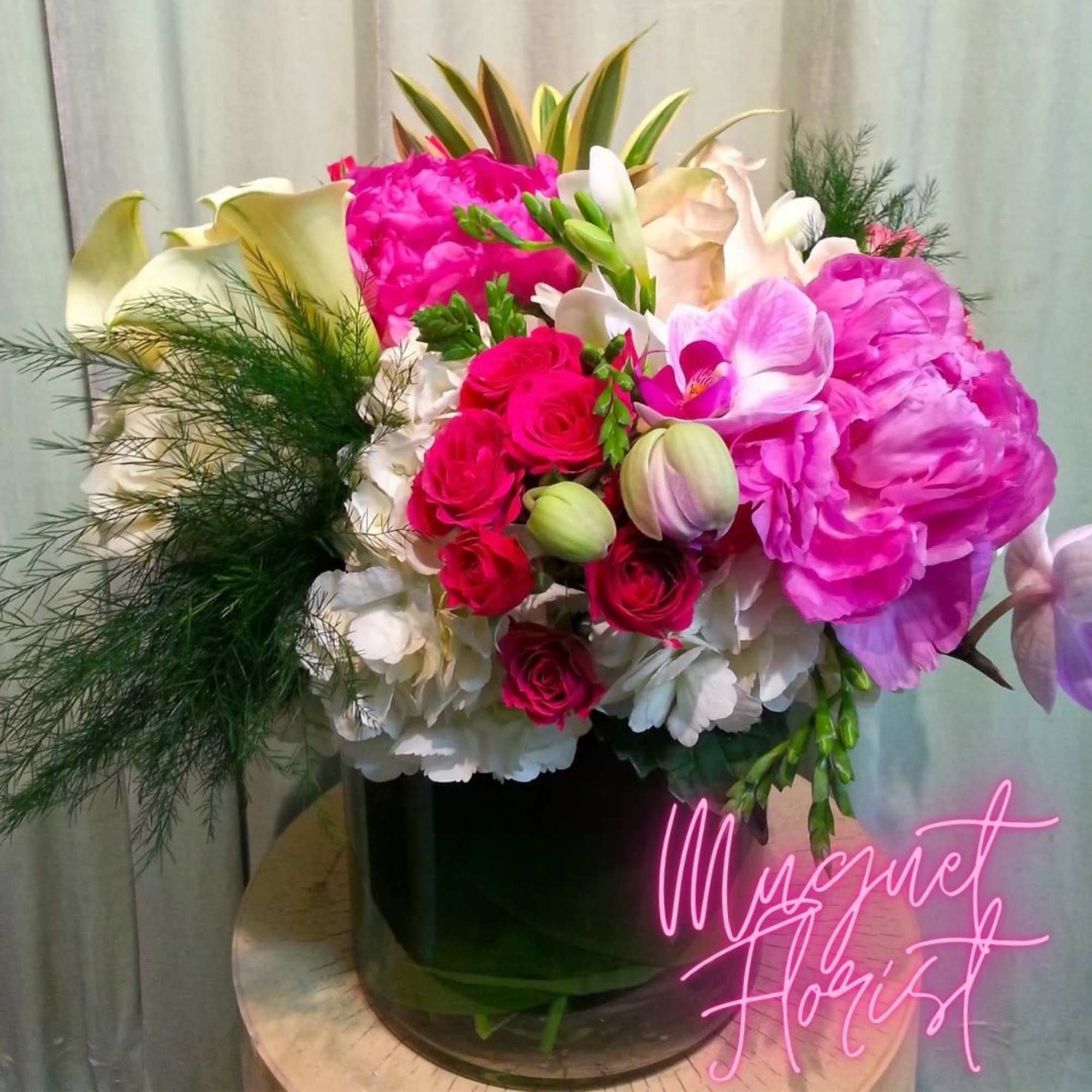 Mixed bouquet of pink and white flowers in a dark vase