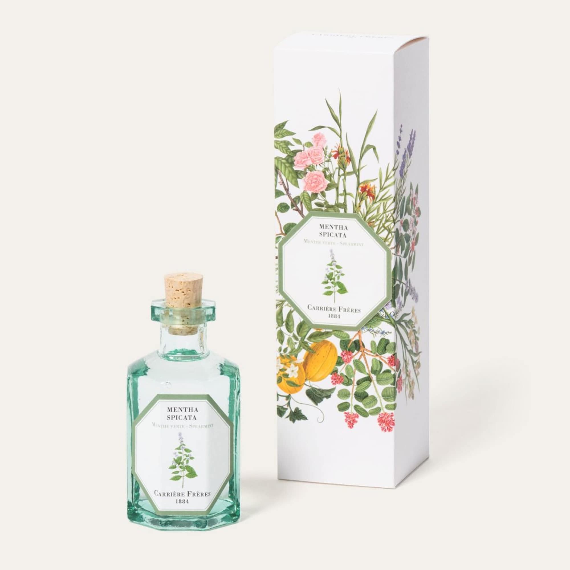 Green glass perfume bottle with matching floral-patterned box