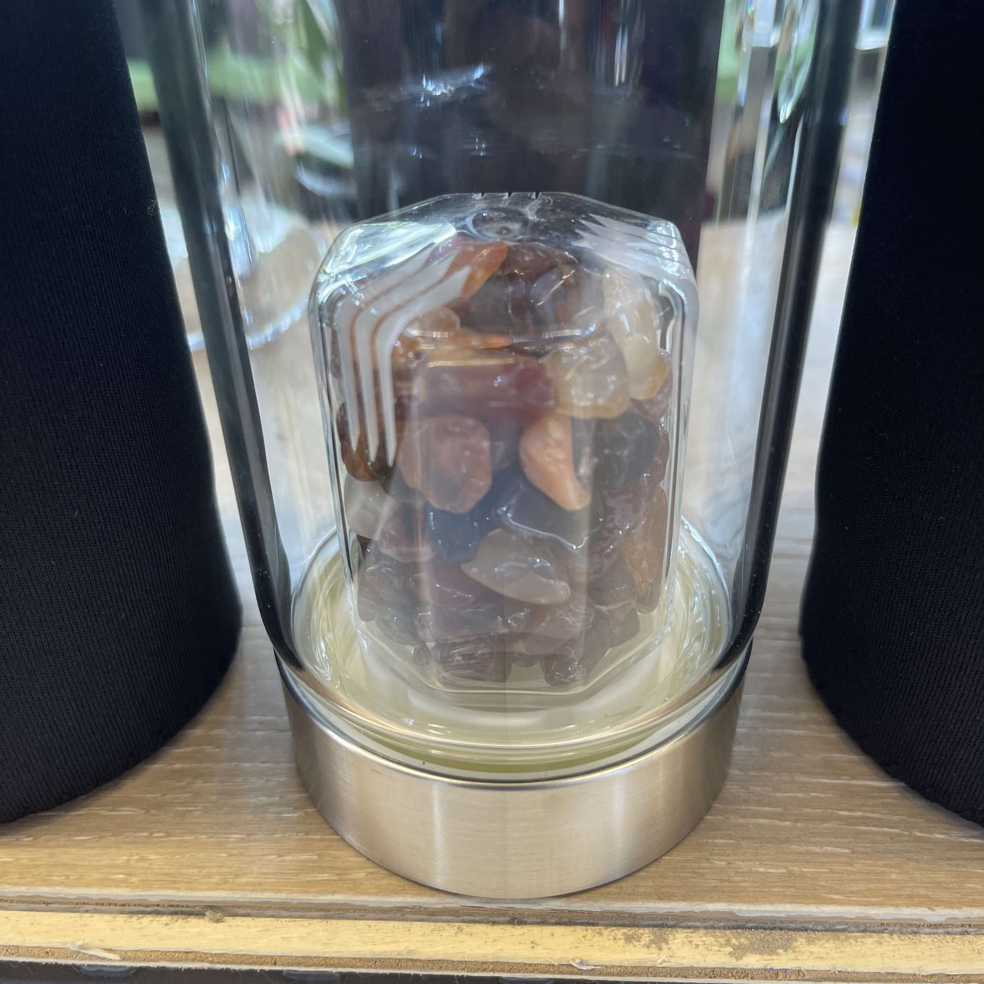 Glass hurricane lamp with a decorative stone-filled center