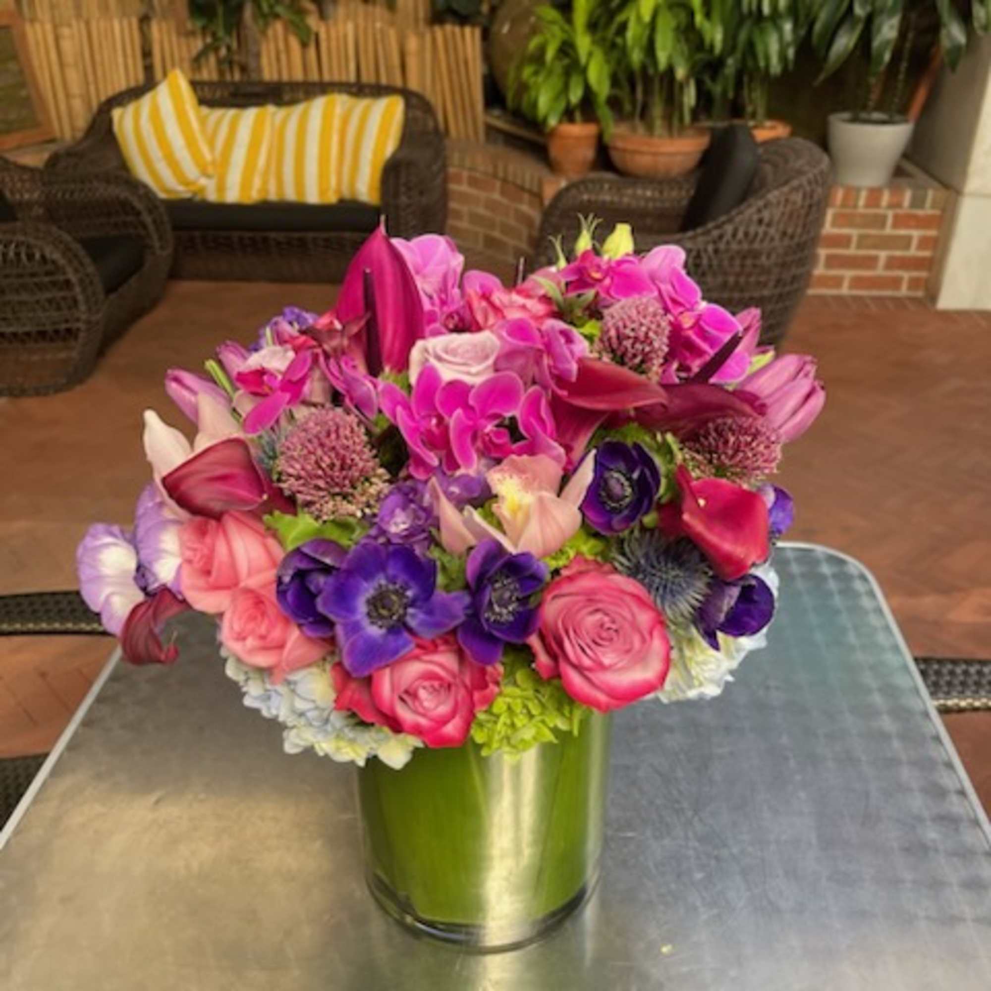 Bright pink and purple mixed bouquet in a green glass vase