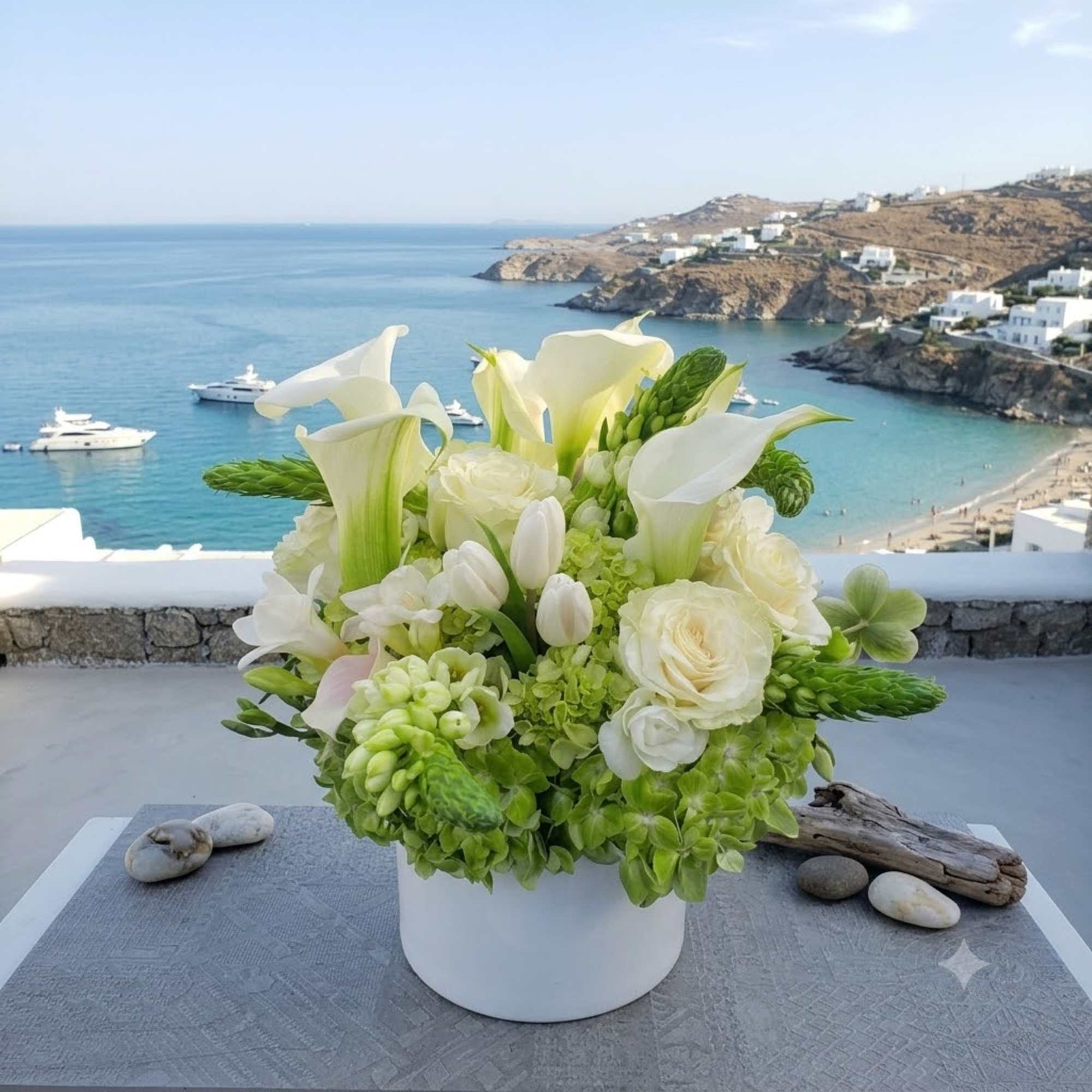 White and green floral arrangement in a white vase with calla lilies and roses
