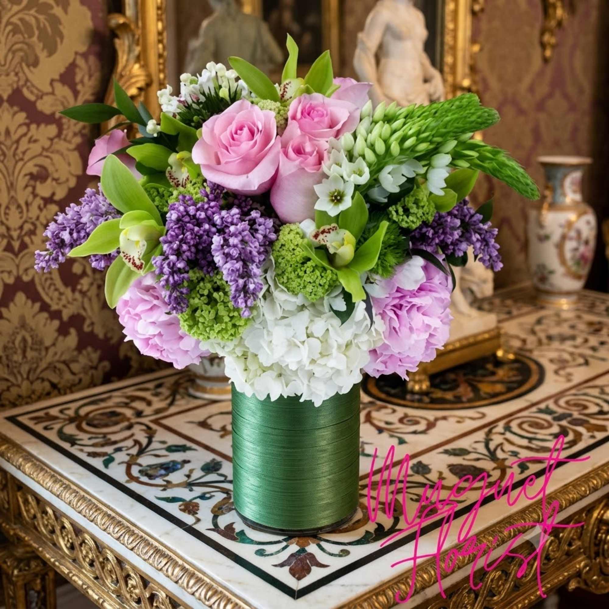 Pink roses and purple flowers arranged in a green cylindrical vase