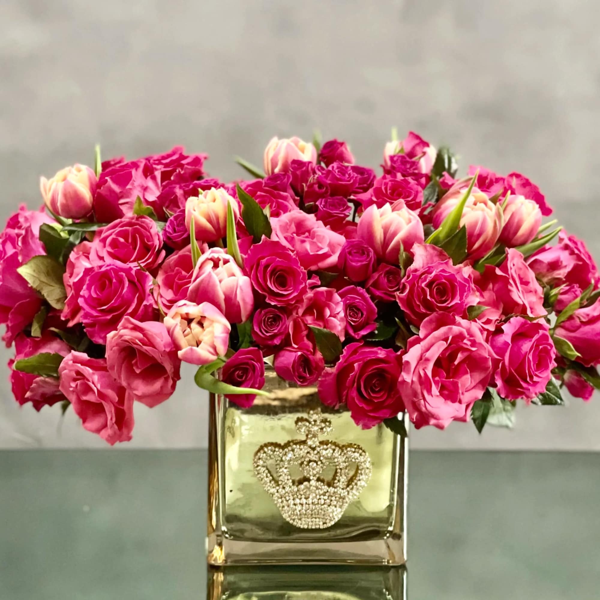 A cluster of pink tulips and roses in a bejeweled crown gold