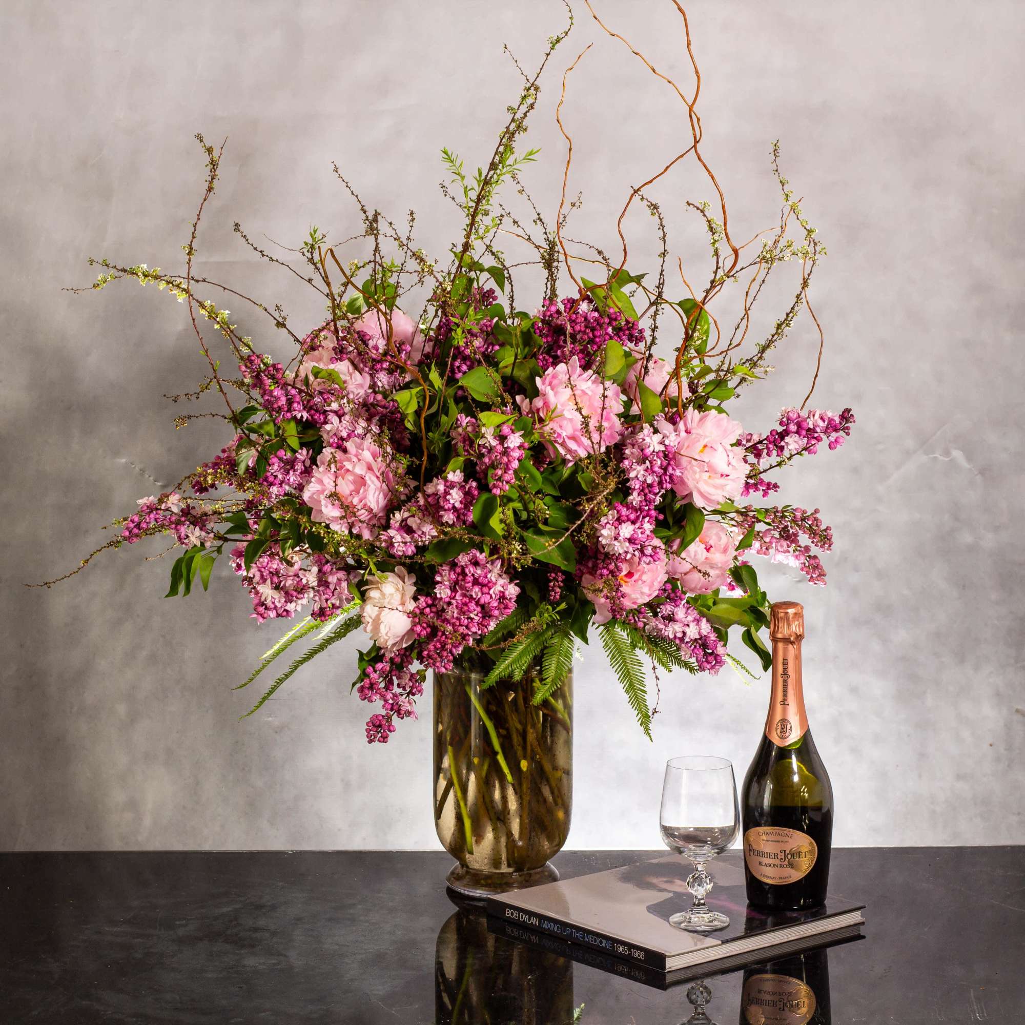 The grand display features an organic arrangement of fragrant lilacs, peonies, and