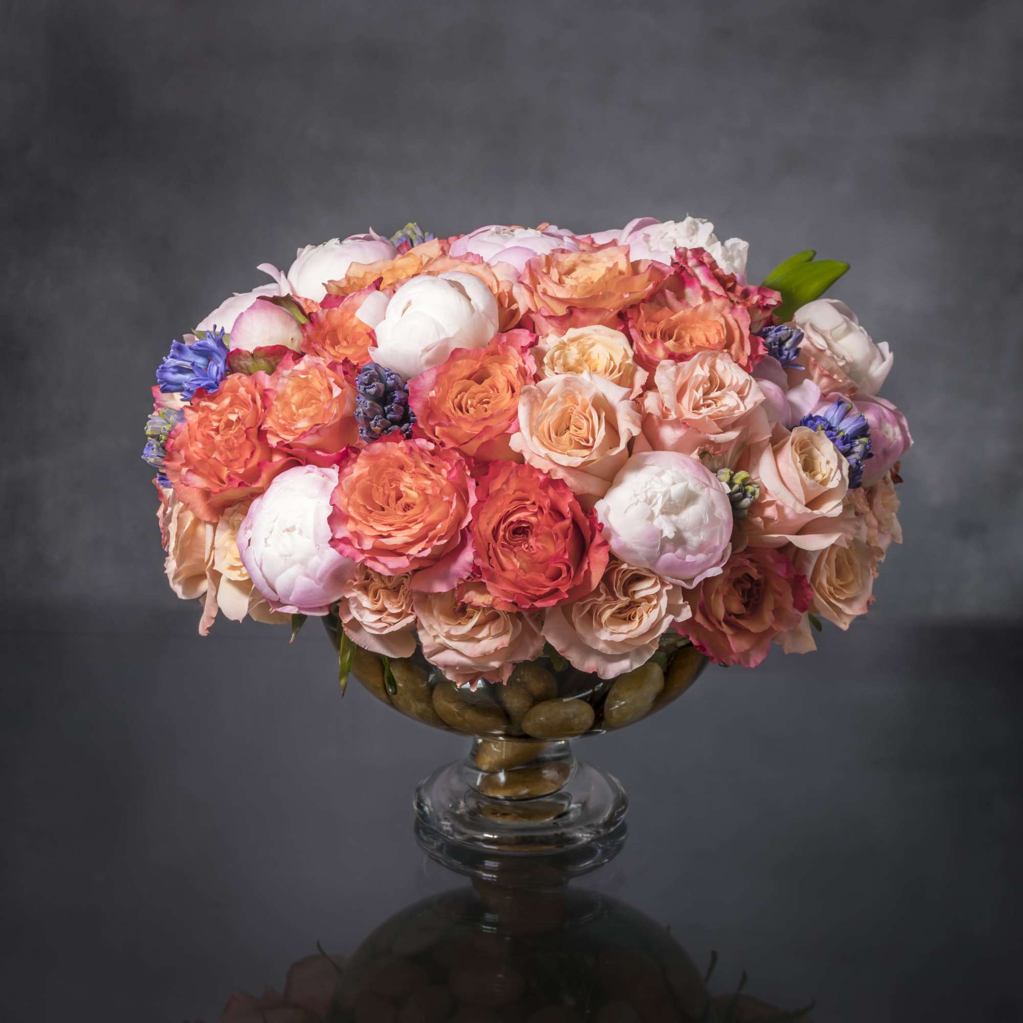Luscious spring-colored blooms highlight this lovely and abundant arrangement. Gorgeous coral and