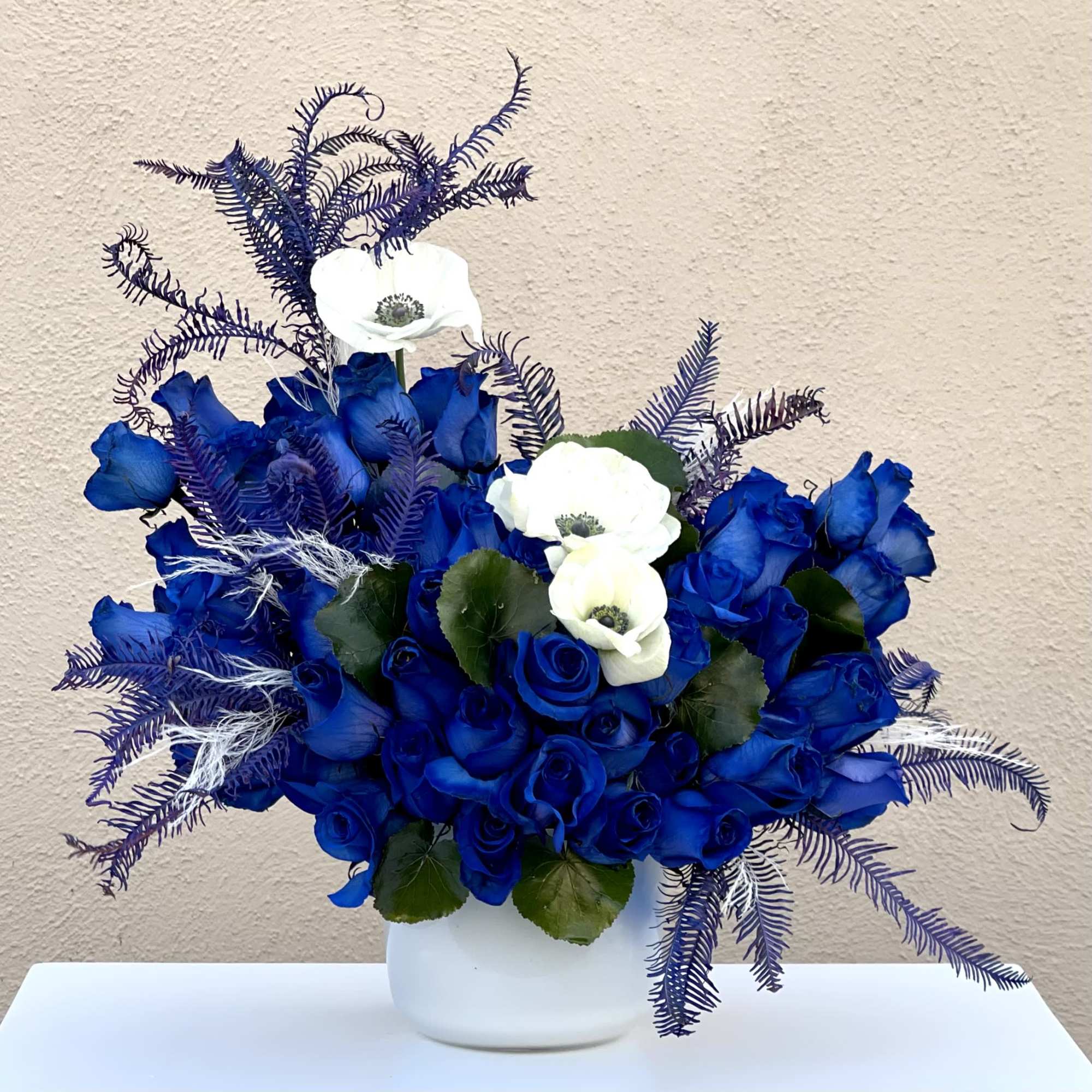 This modern blue arrangement featuring over 50 blooms of blue roses and