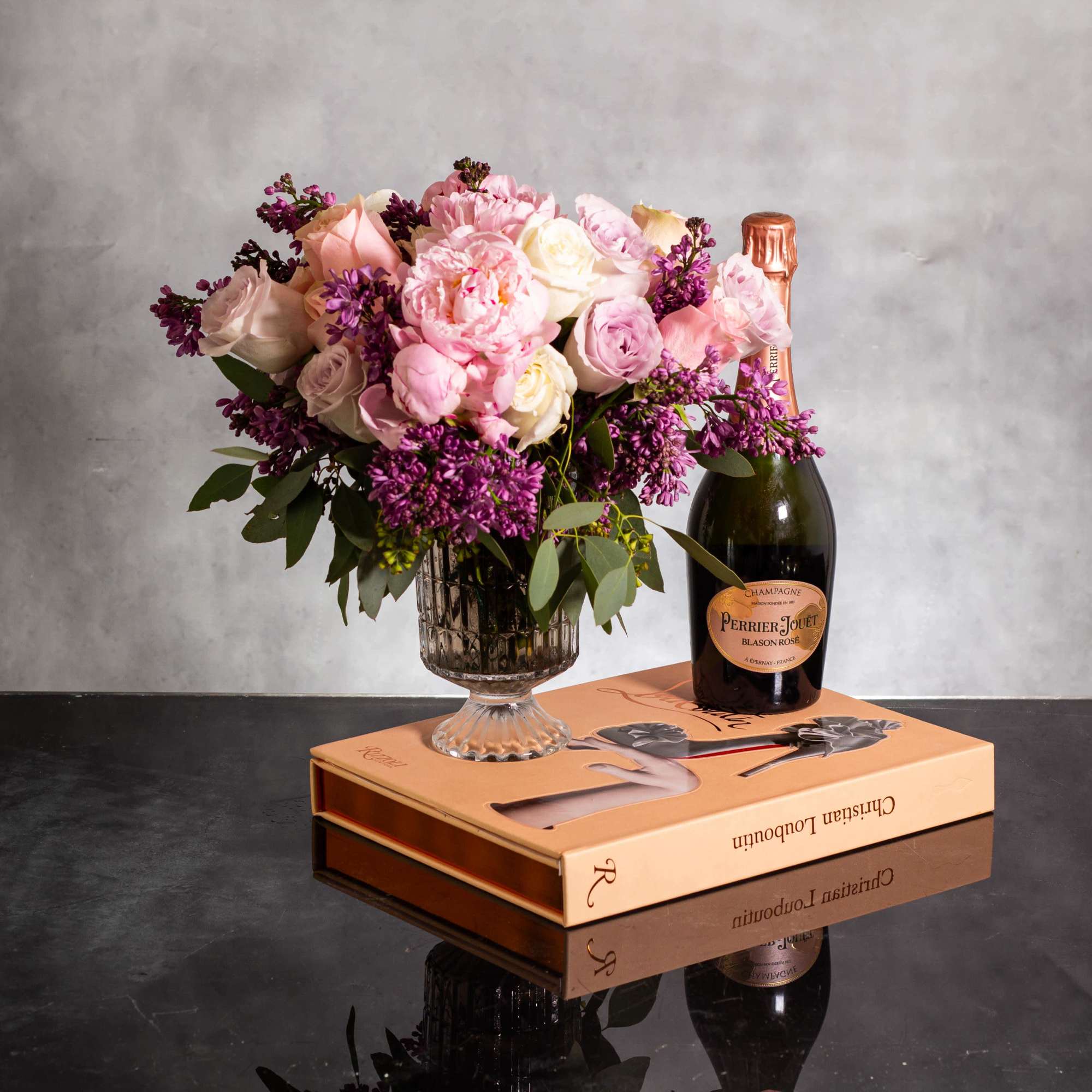 The luxurious floral arrangement features peonies, spray roses, and lilac artfully arranged