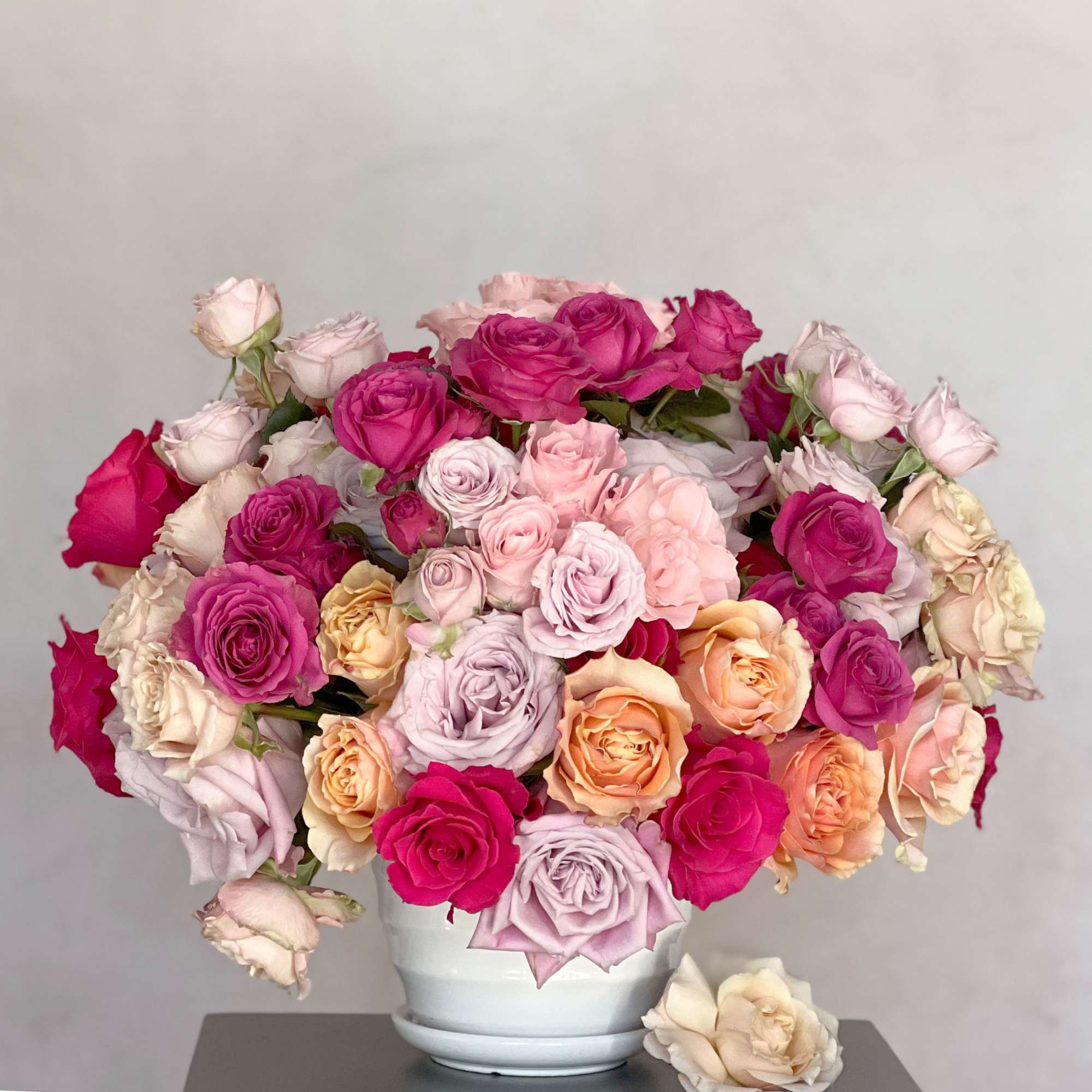 Bouquet of pink, peach, and cream roses in a white vase, photo 2 of 3