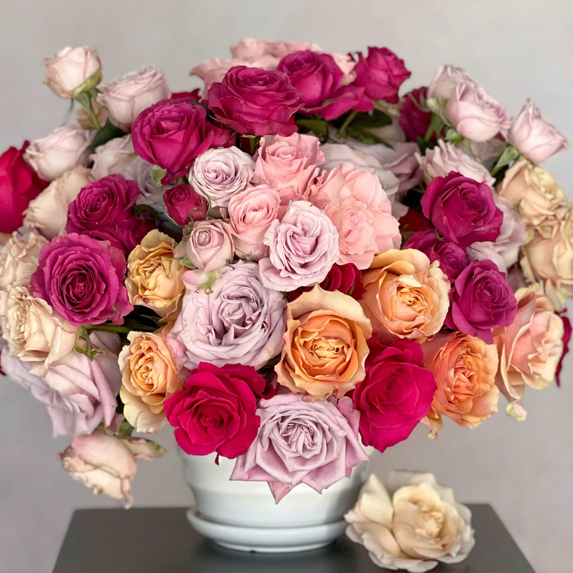 Bouquet of multicolored roses in a white vase