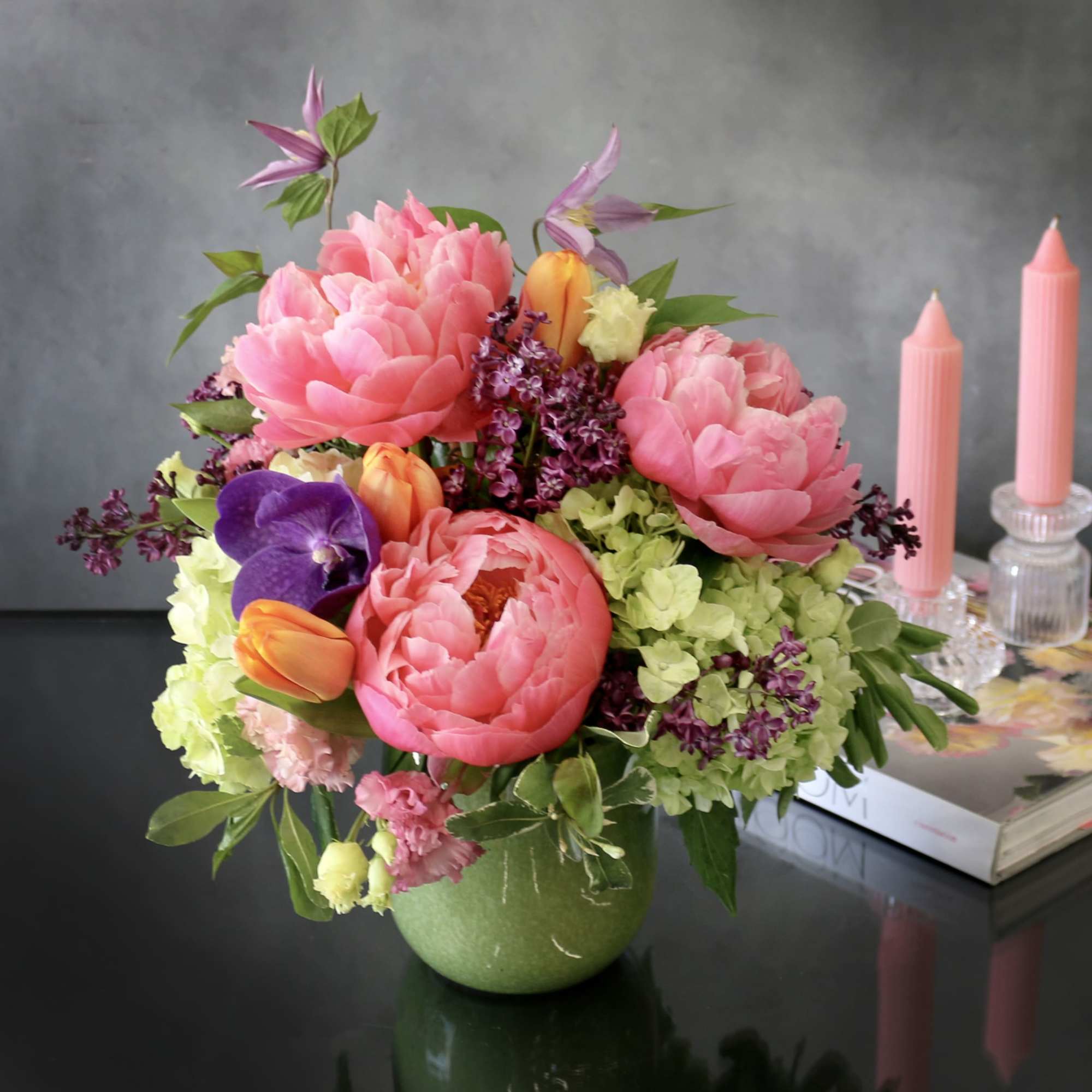 Peonies, vanda orchids, lilac and orange tulips and green hydrangeas in a