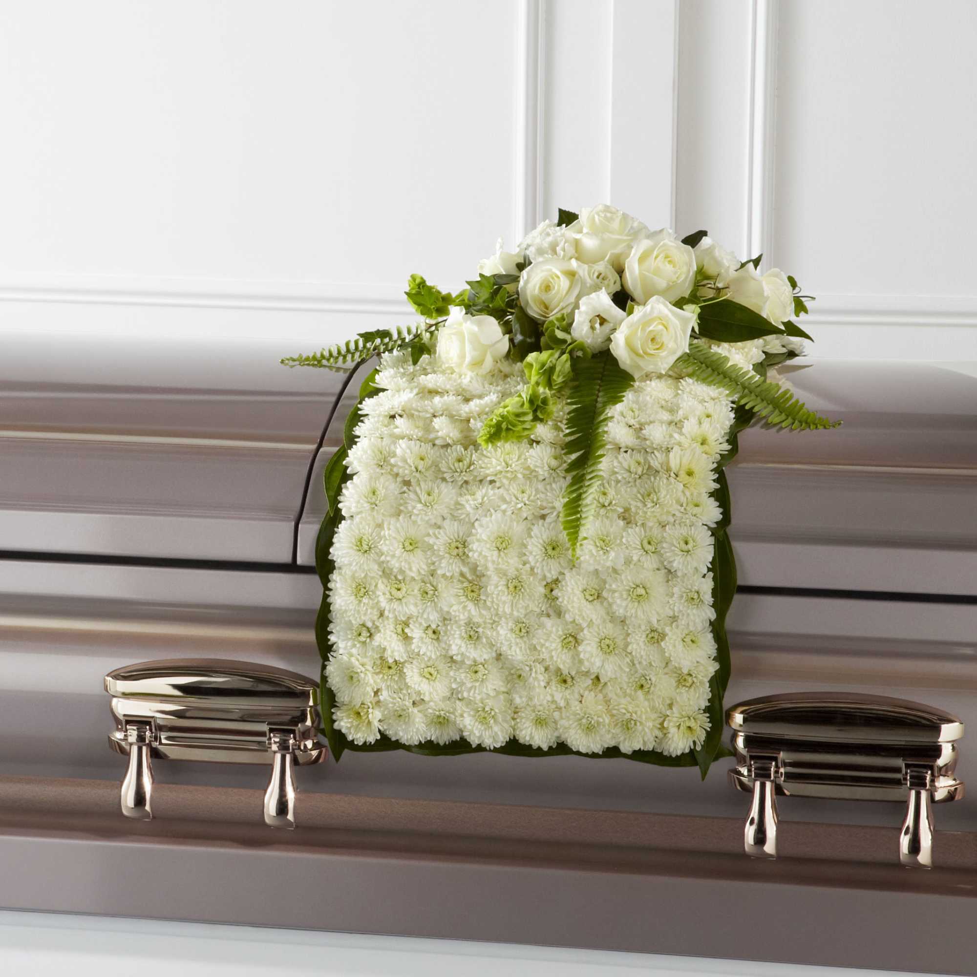 White floral casket spray with roses and chrysanthemums