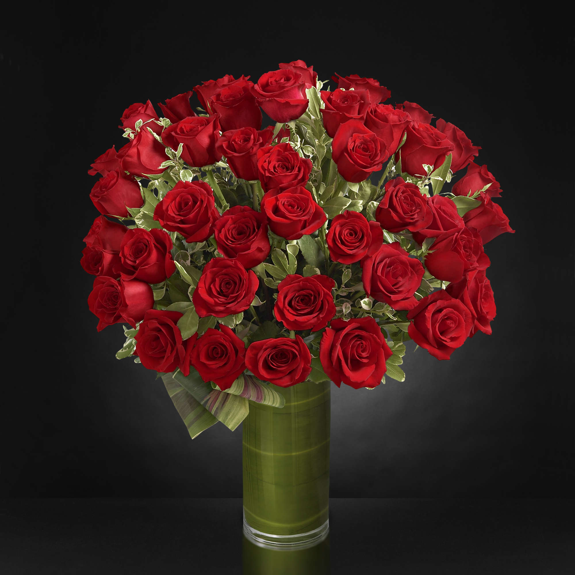 Bouquet of red roses in a tall glass vase