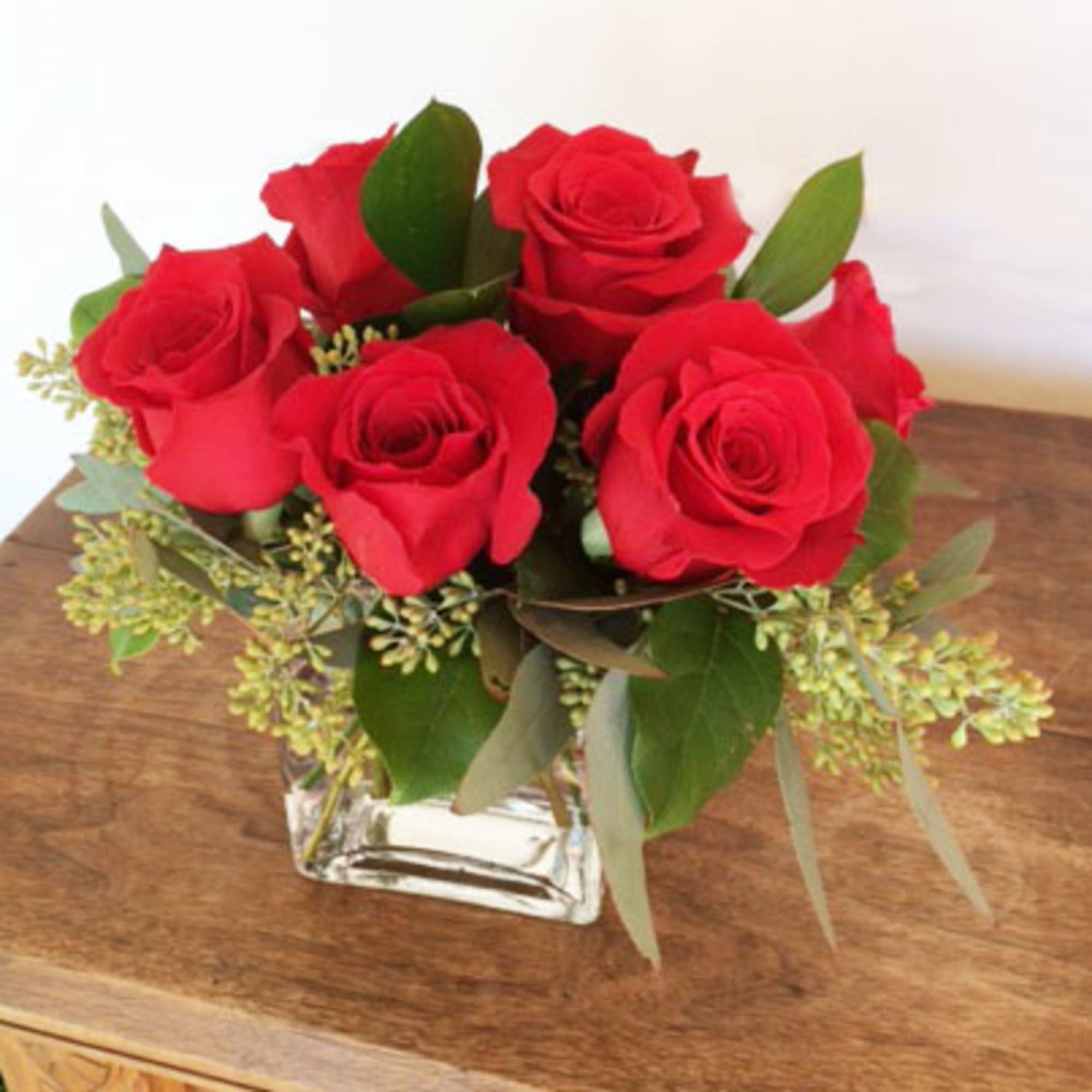 Red roses arranged in a clear square glass vase, photo 2 of 2