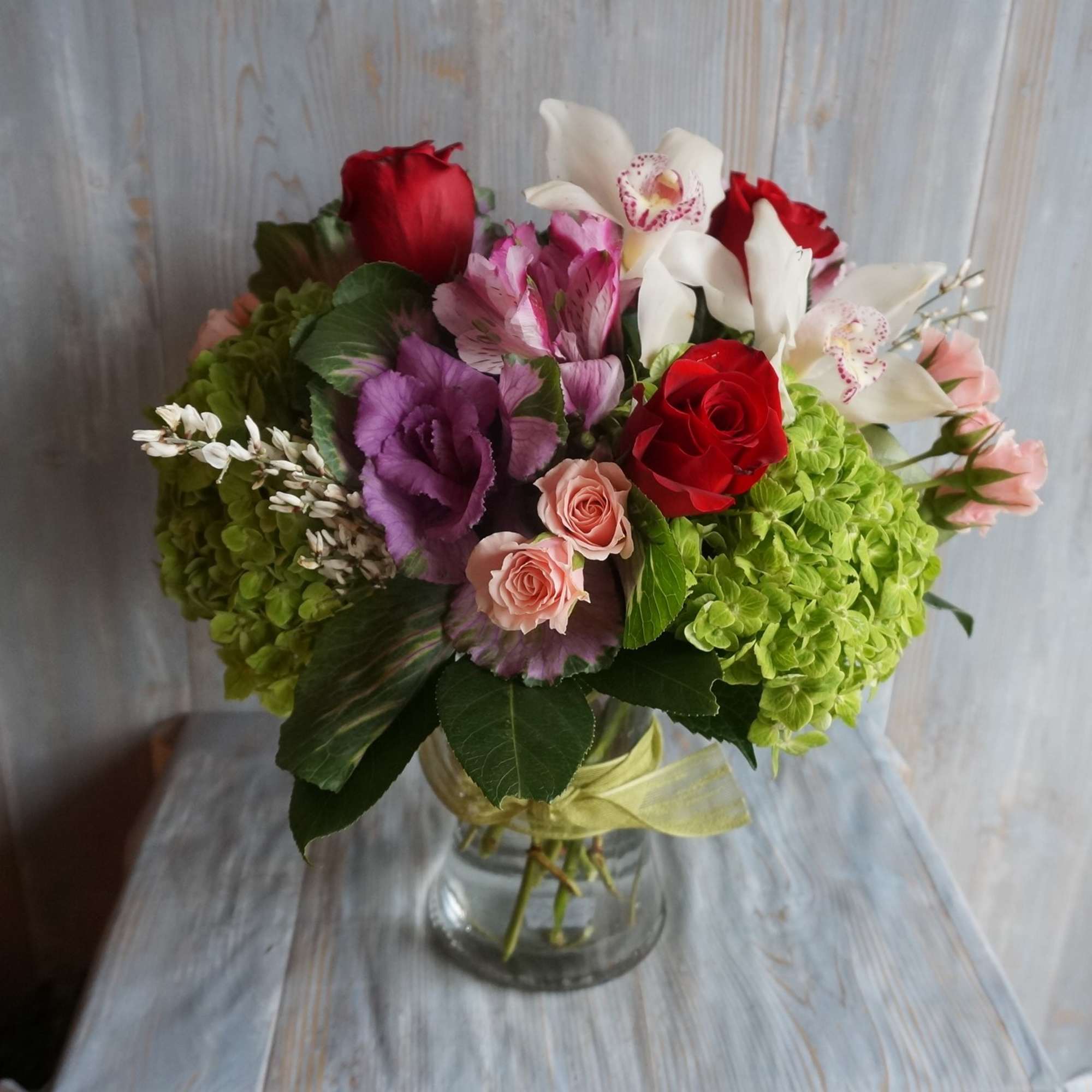 Bouquet of red, pink, purple, and white flowers in a glass vase