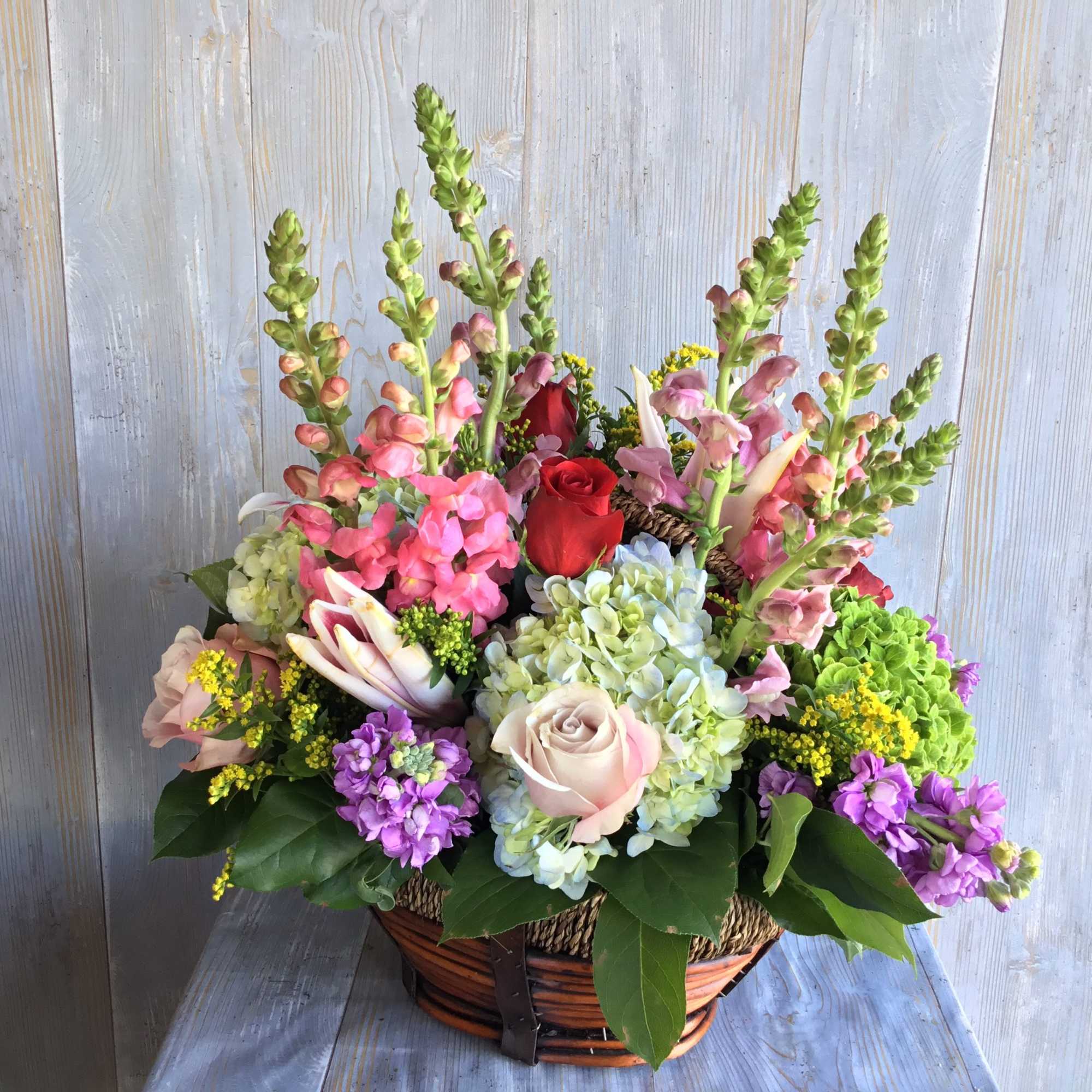 Pretty spring basket filled with hydrangea, snap dragons, roses and other colorful, photo 2 of 2