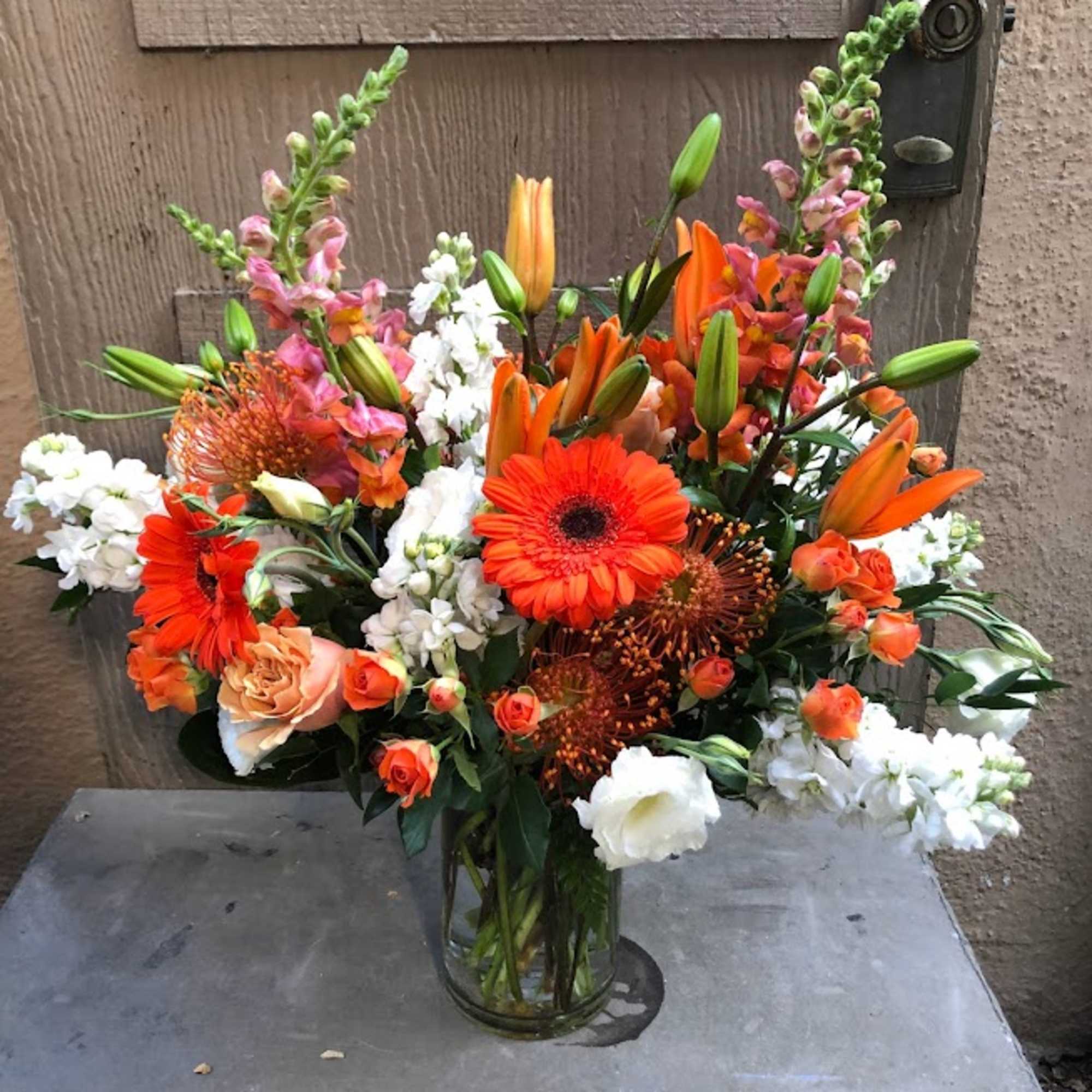 Orange and white mixed bouquet in a glass vase