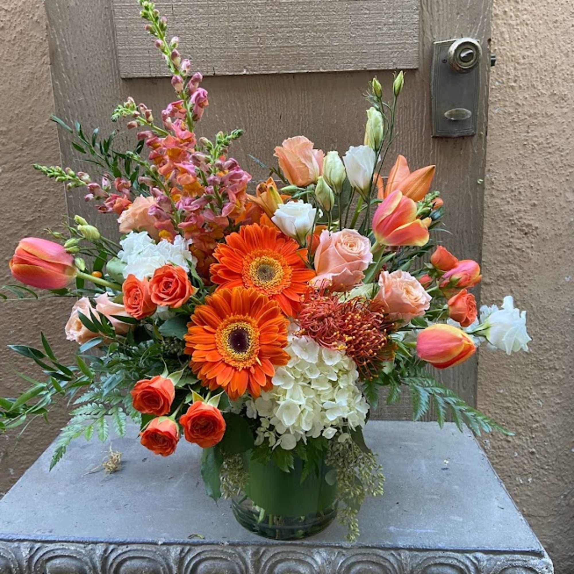 Orange and peach mixed bouquet in a glass vase