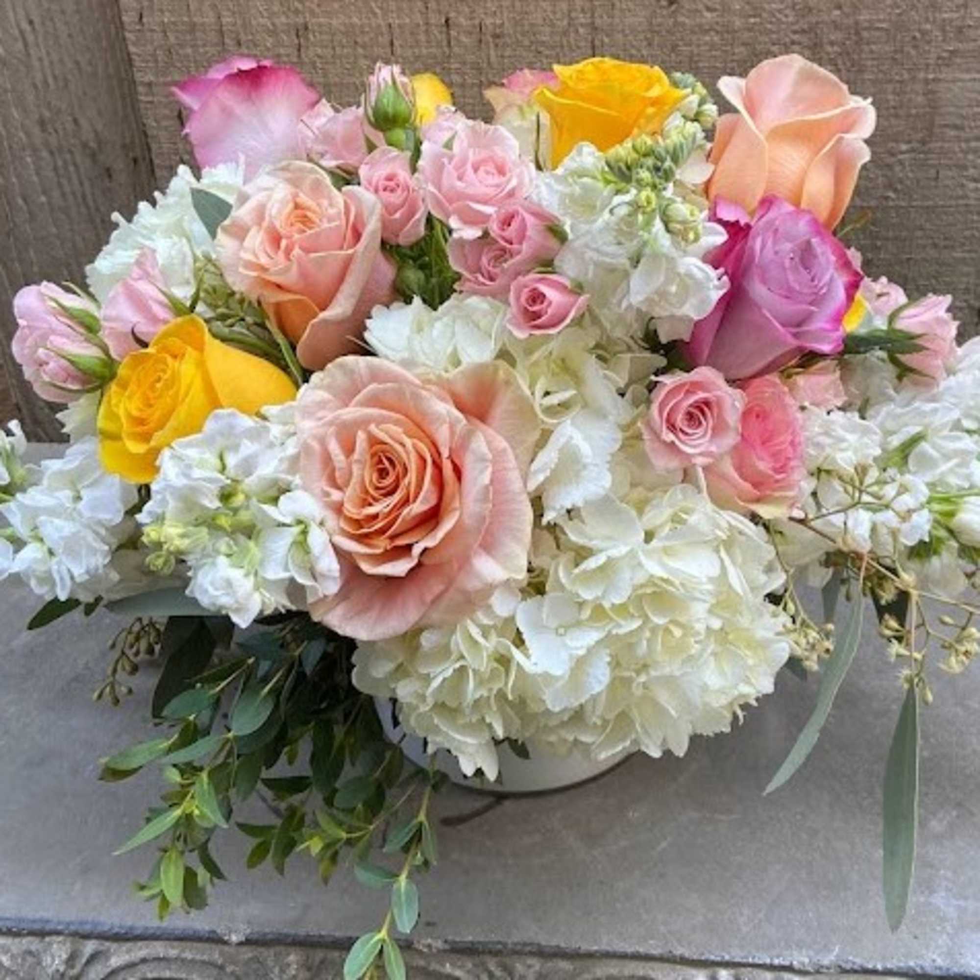 Mixed pastel bouquet in a low white container