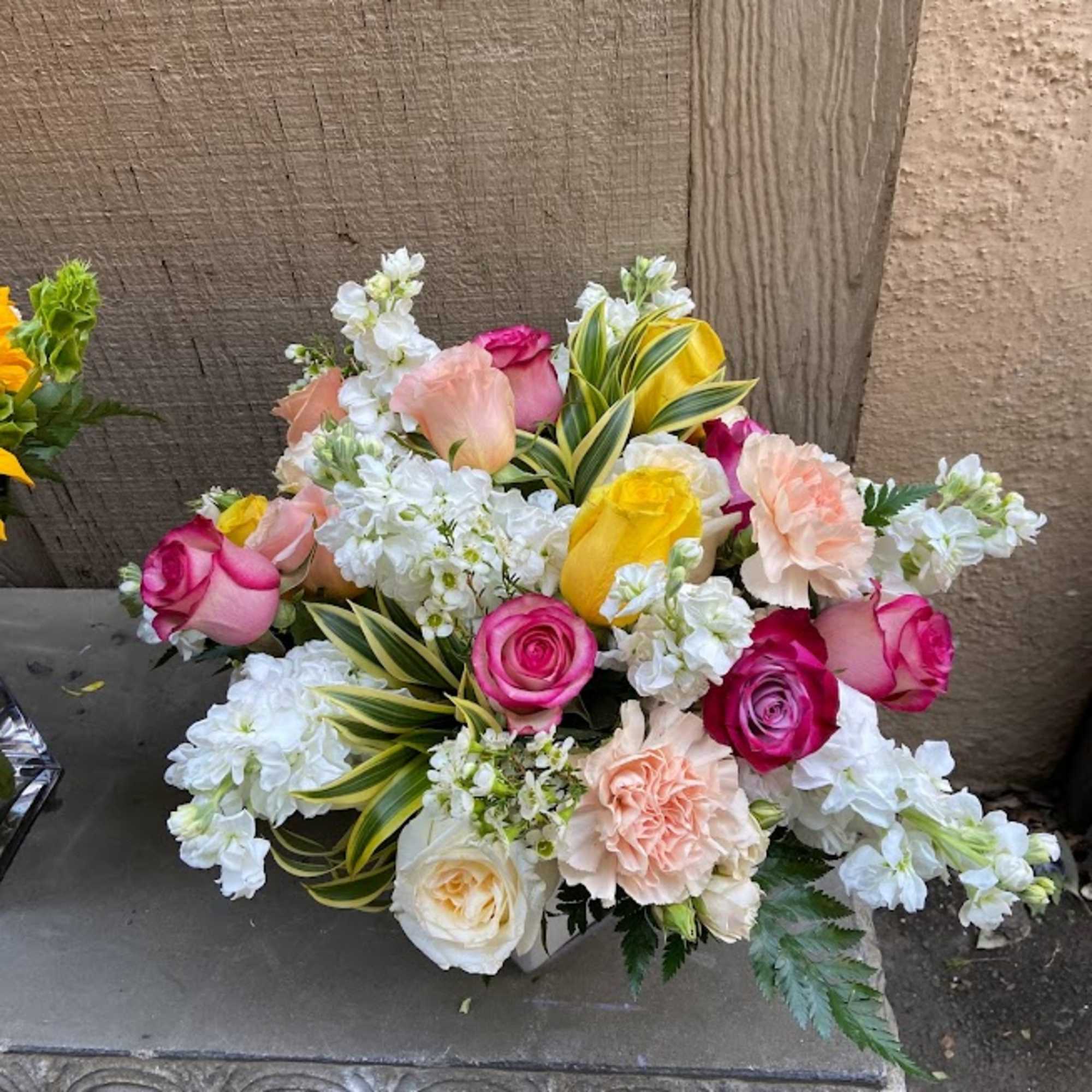 Mixed bouquet of pink, yellow, peach, and white flowers