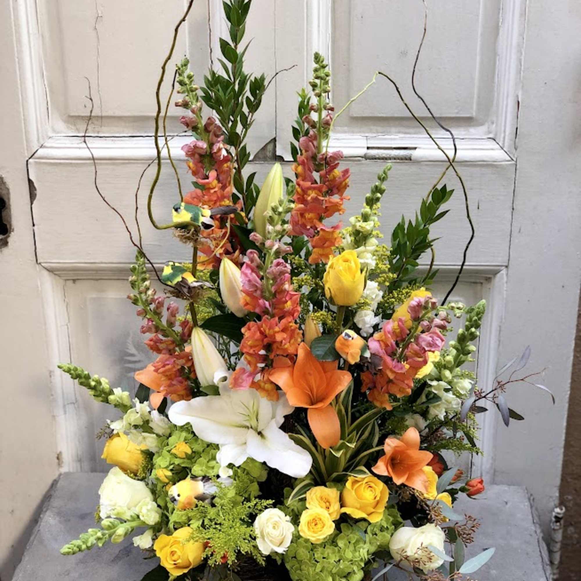 Tall mixed flower arrangement with lilies, roses, and snapdragons