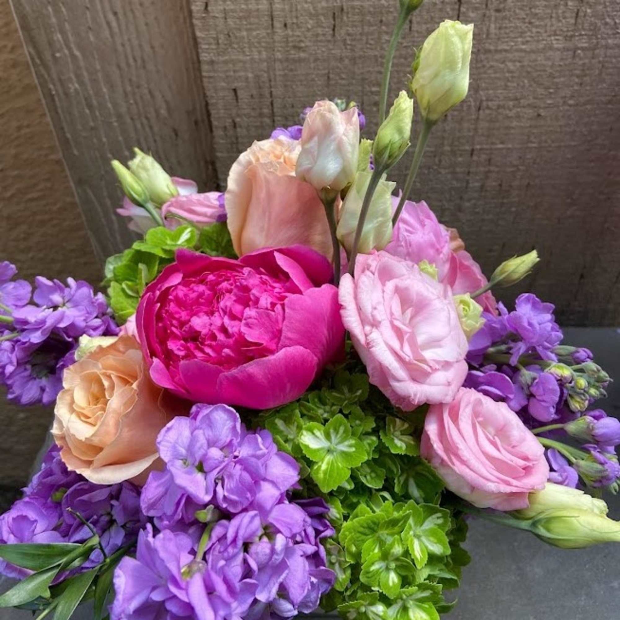 Bouquet of pink and purple flowers with green accents