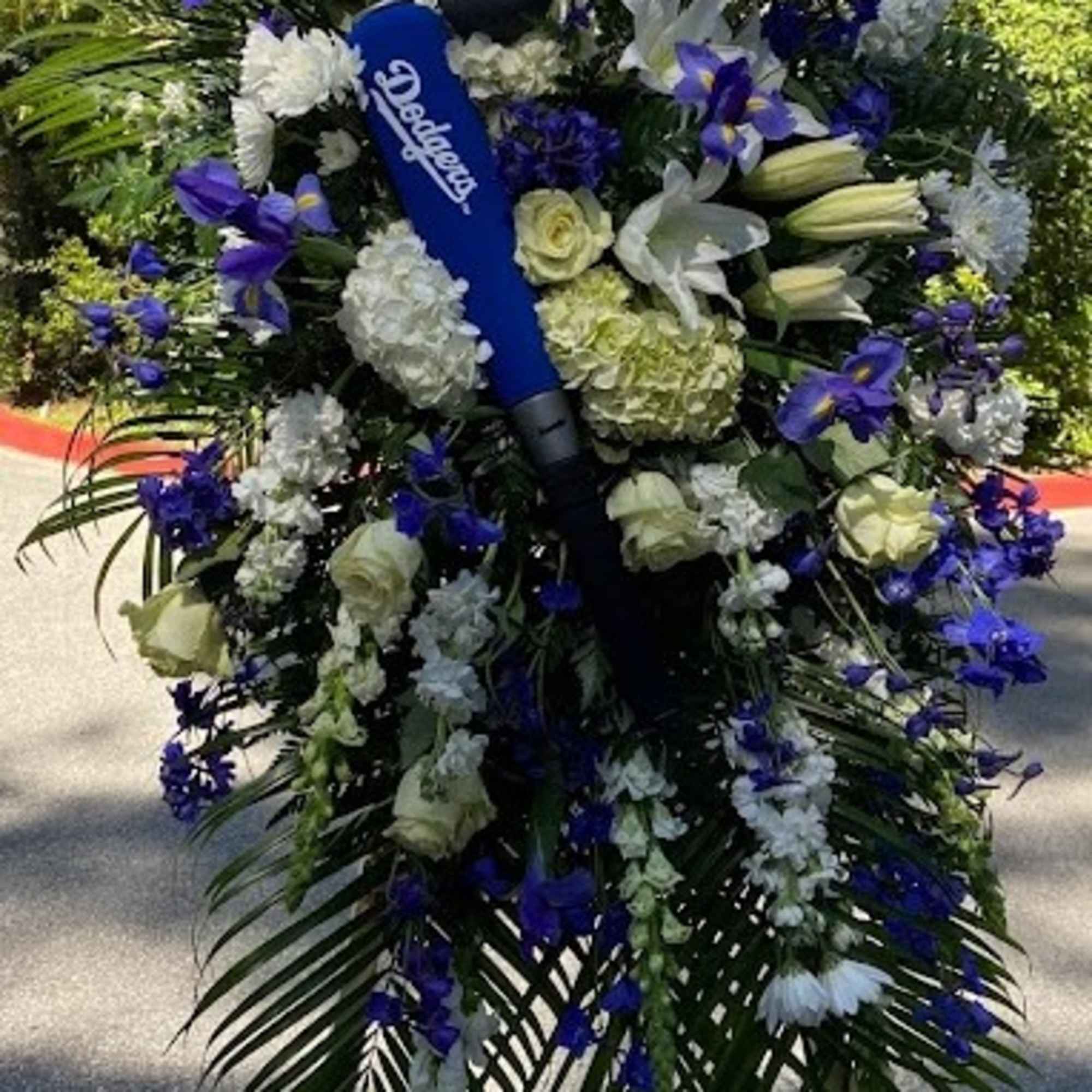 Large blue and white floral standing spray with a Dodgers cap centerpiece