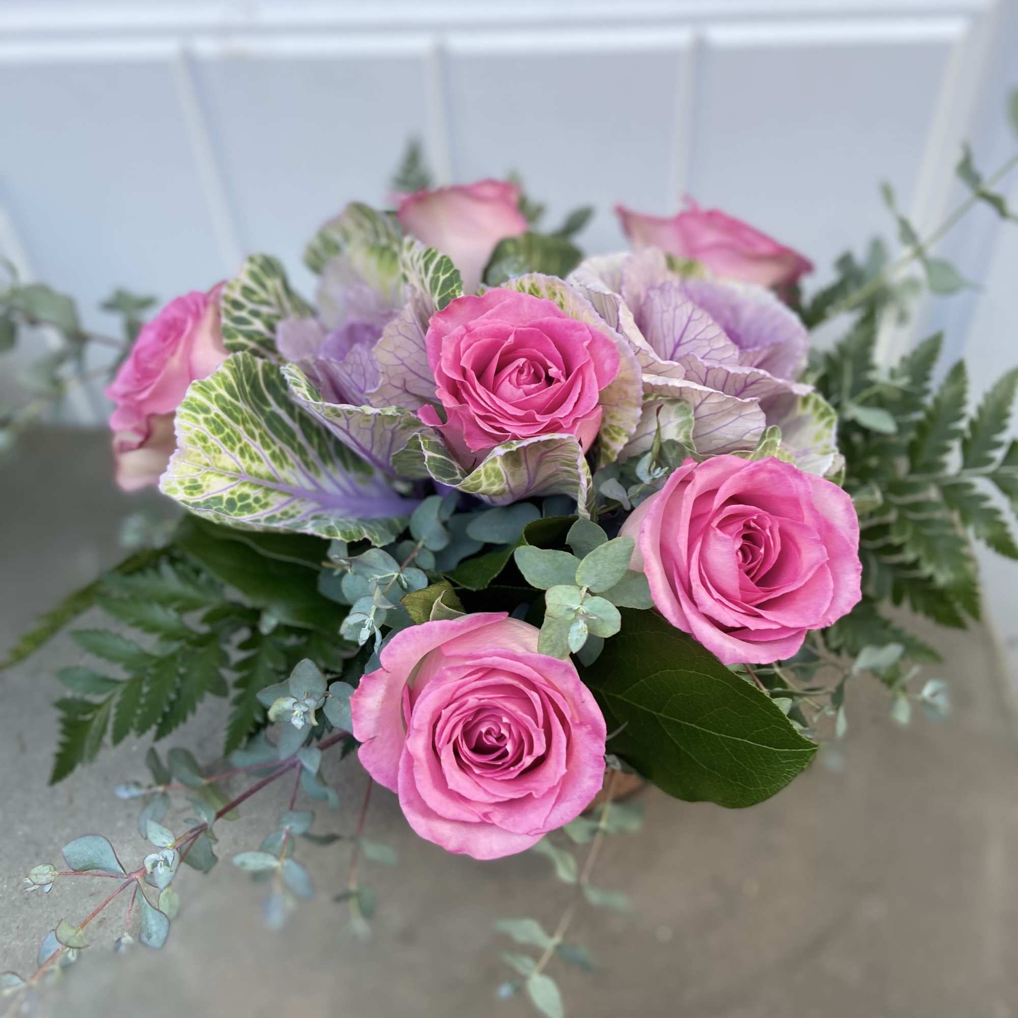 Pink roses with ornamental cabbage and eucalyptus in a bouquet