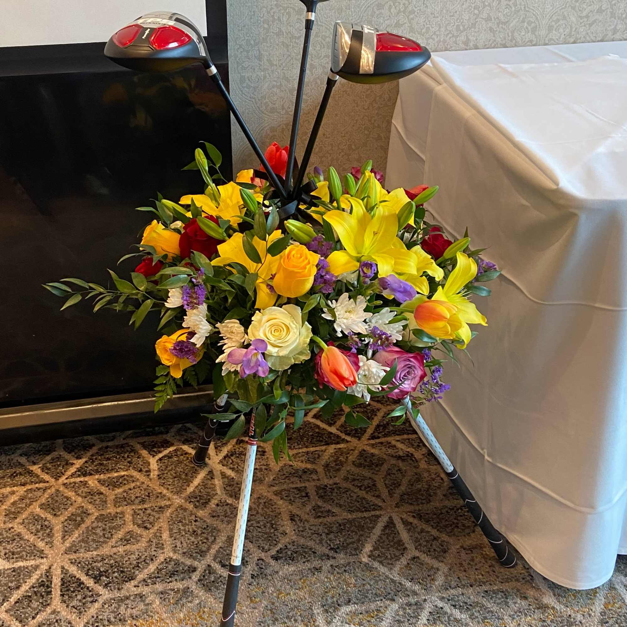 Golf-club-themed floral arrangement with bright mixed flowers