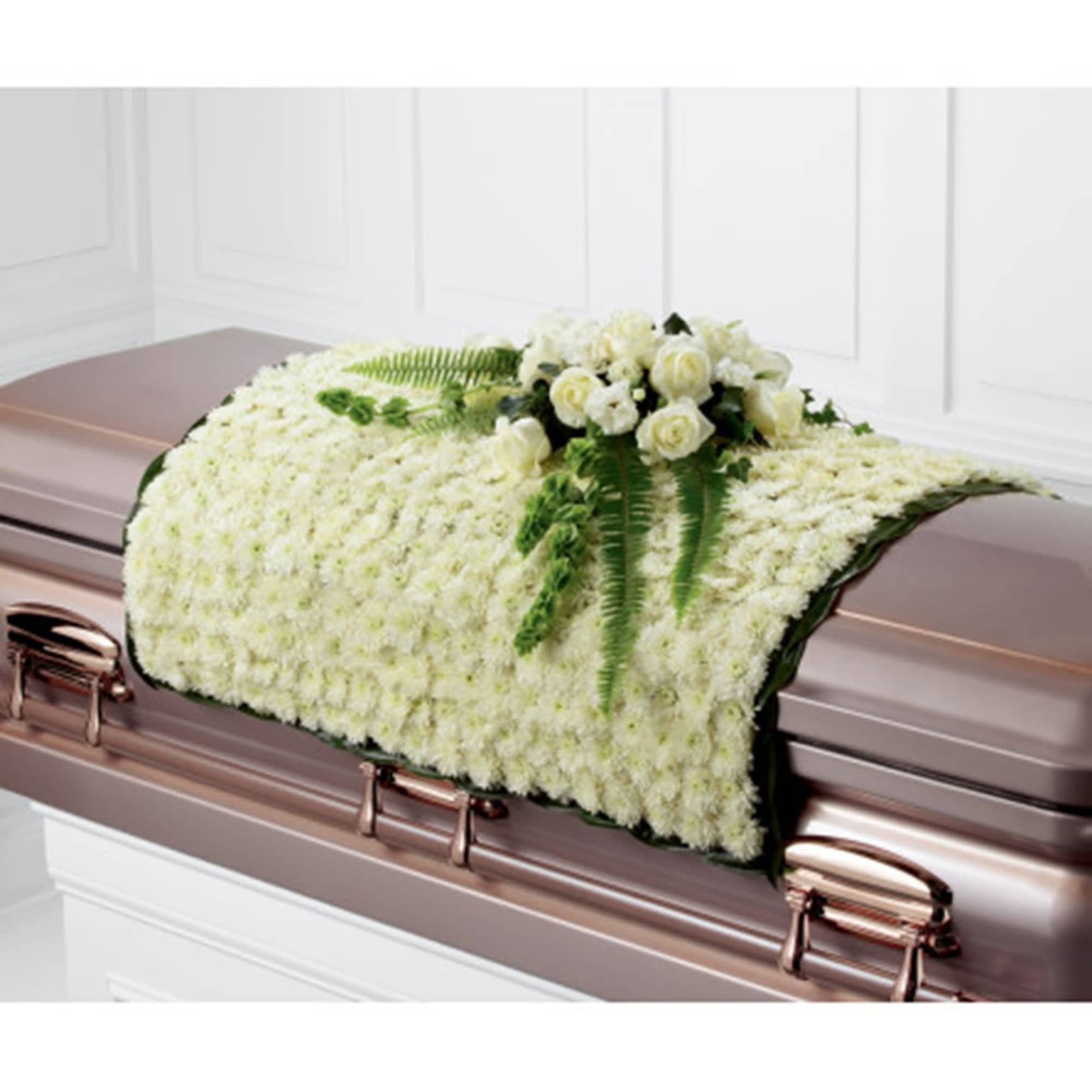 White floral casket spray with roses and fern accents