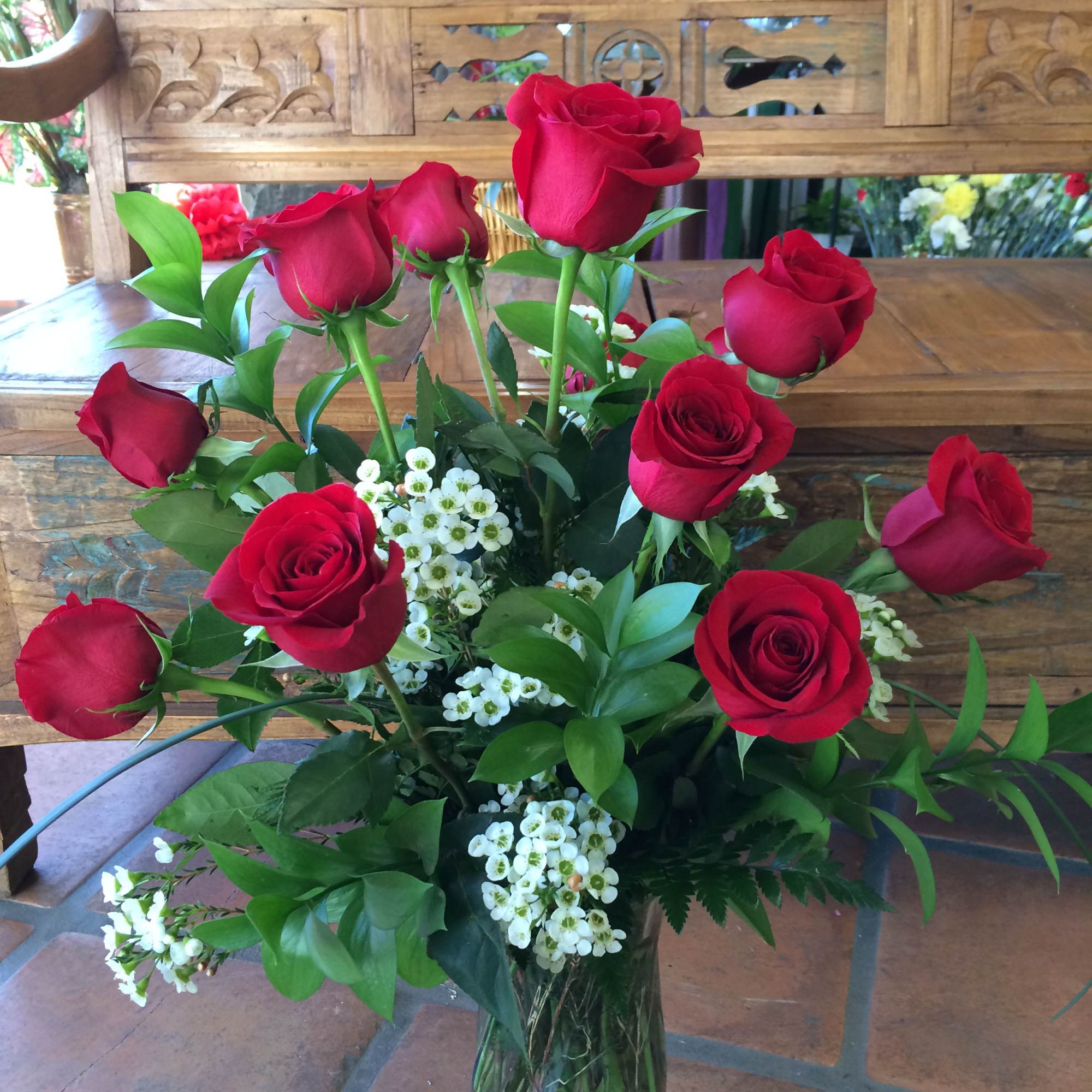 Bouquet of red roses and white filler flowers in a glass vase