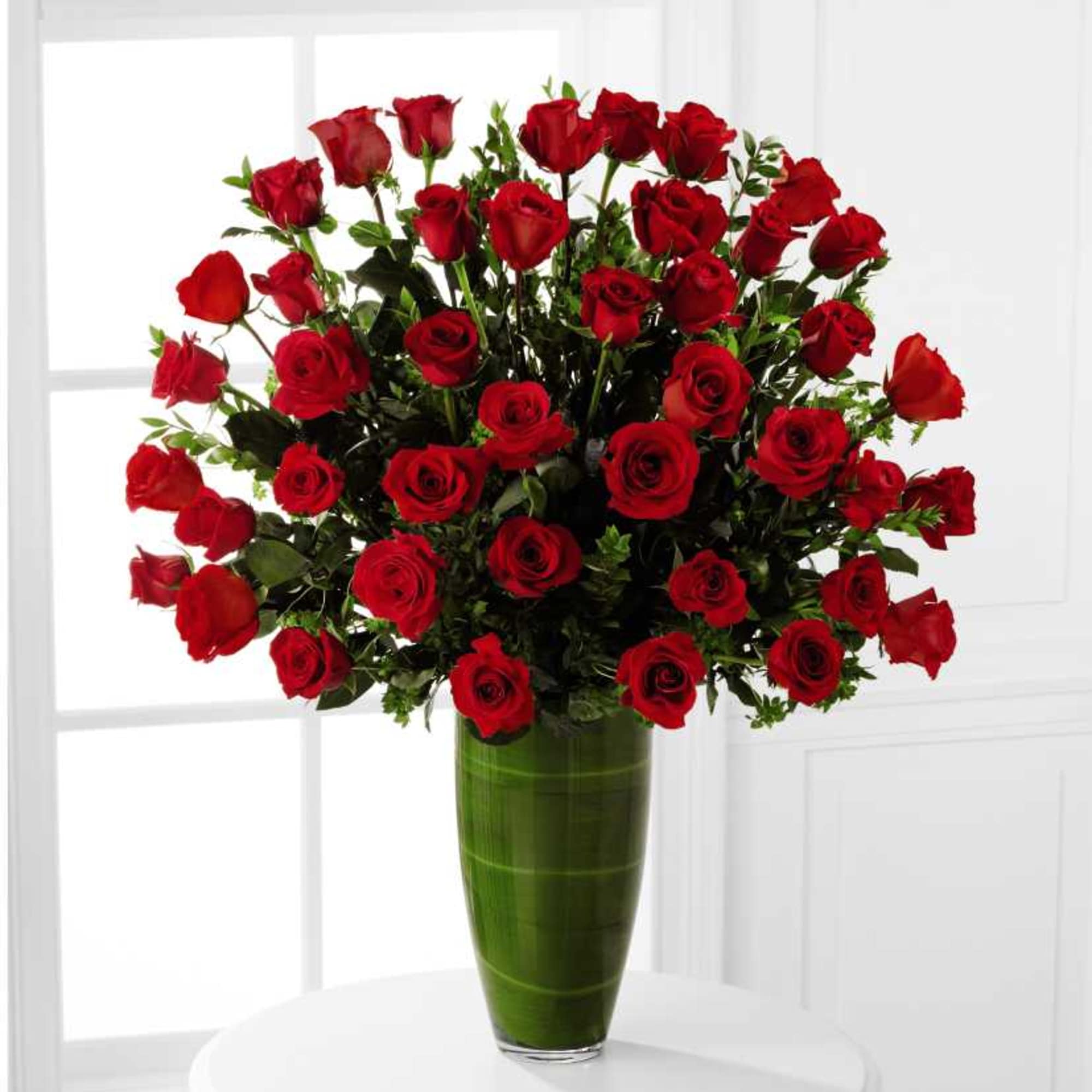 Bouquet of red roses in a tall green vase