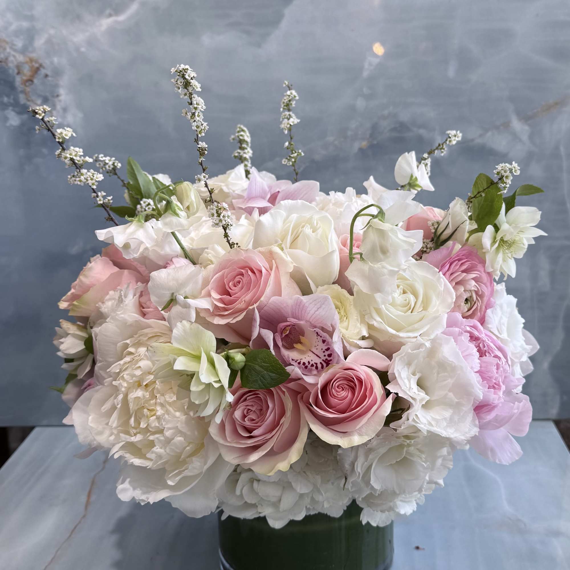A soft, romantic blend of blush pinks and creamy whites, this arrangement