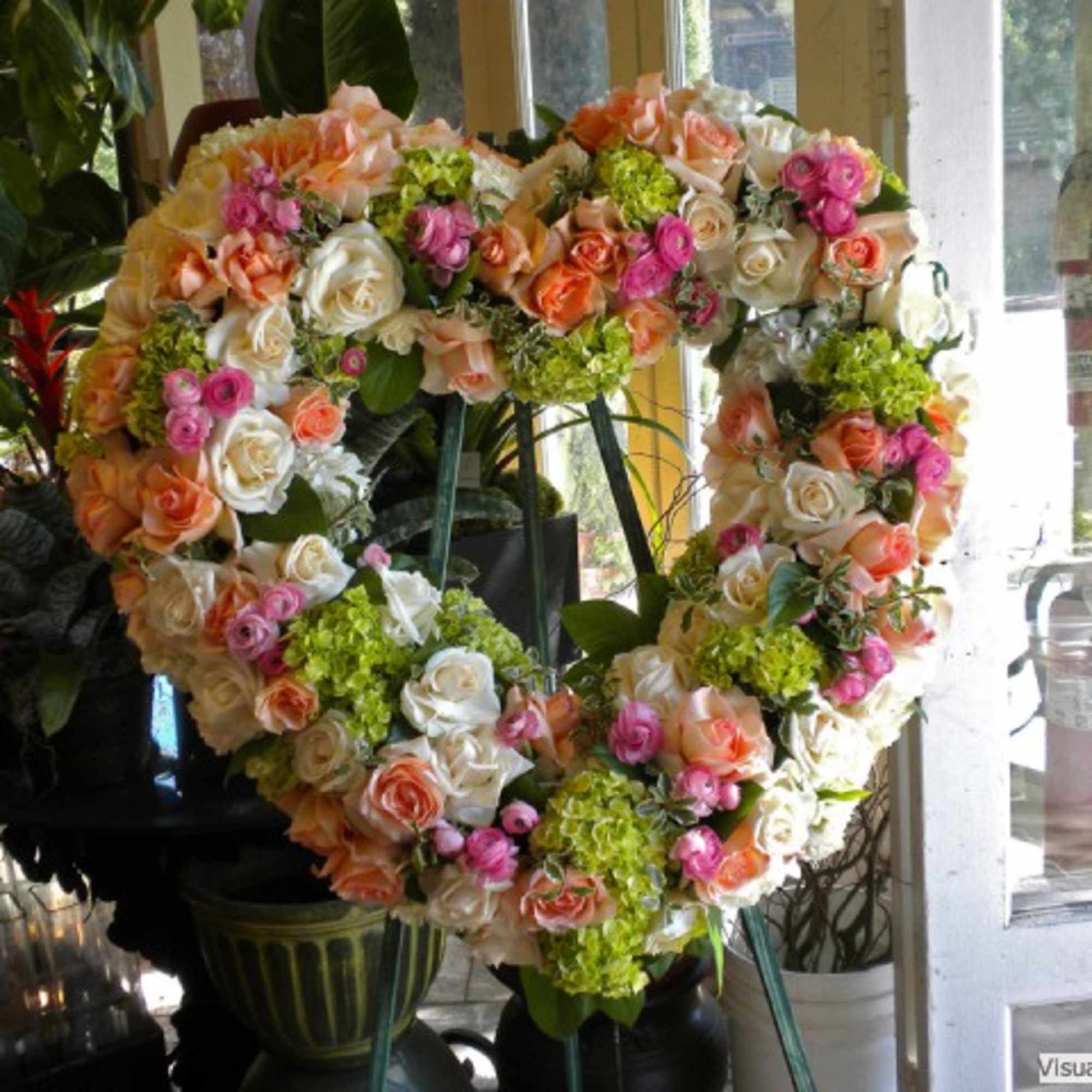 Heart-shaped floral wreath of roses and hydrangeas on an easel, photo 2 of 3