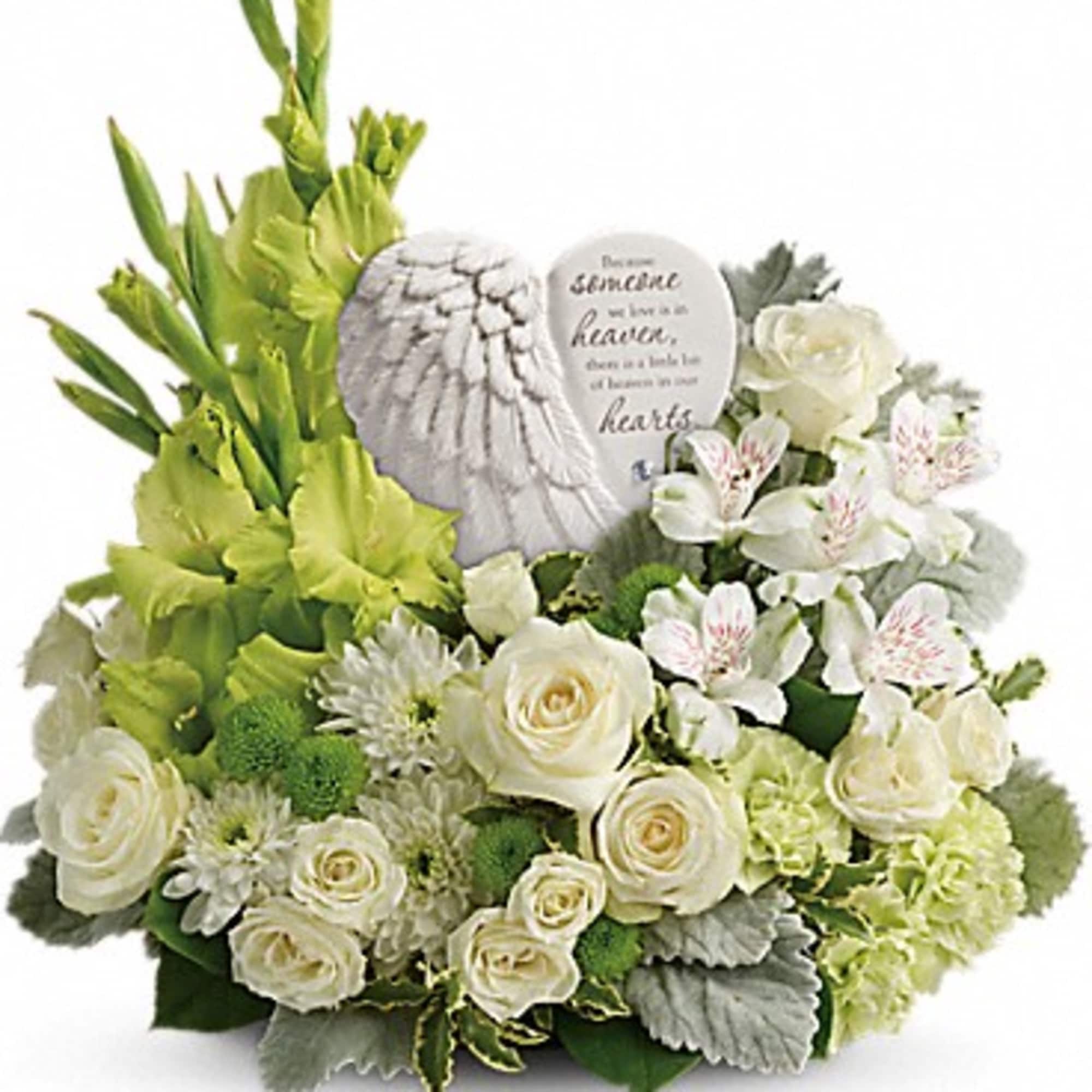 White floral arrangement with a memorial stone and green blooms