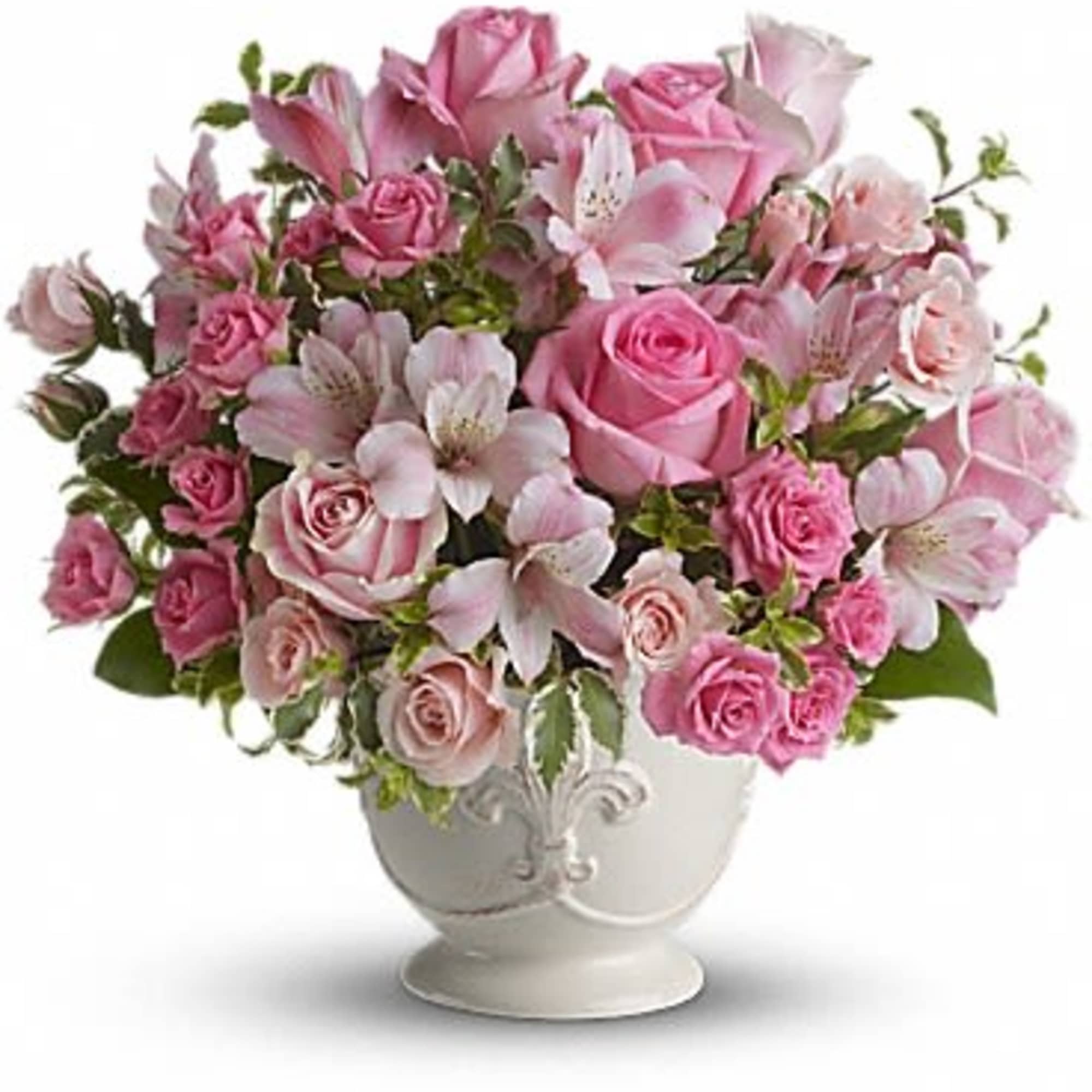 Pink roses and alstroemeria arranged in a white urn vase