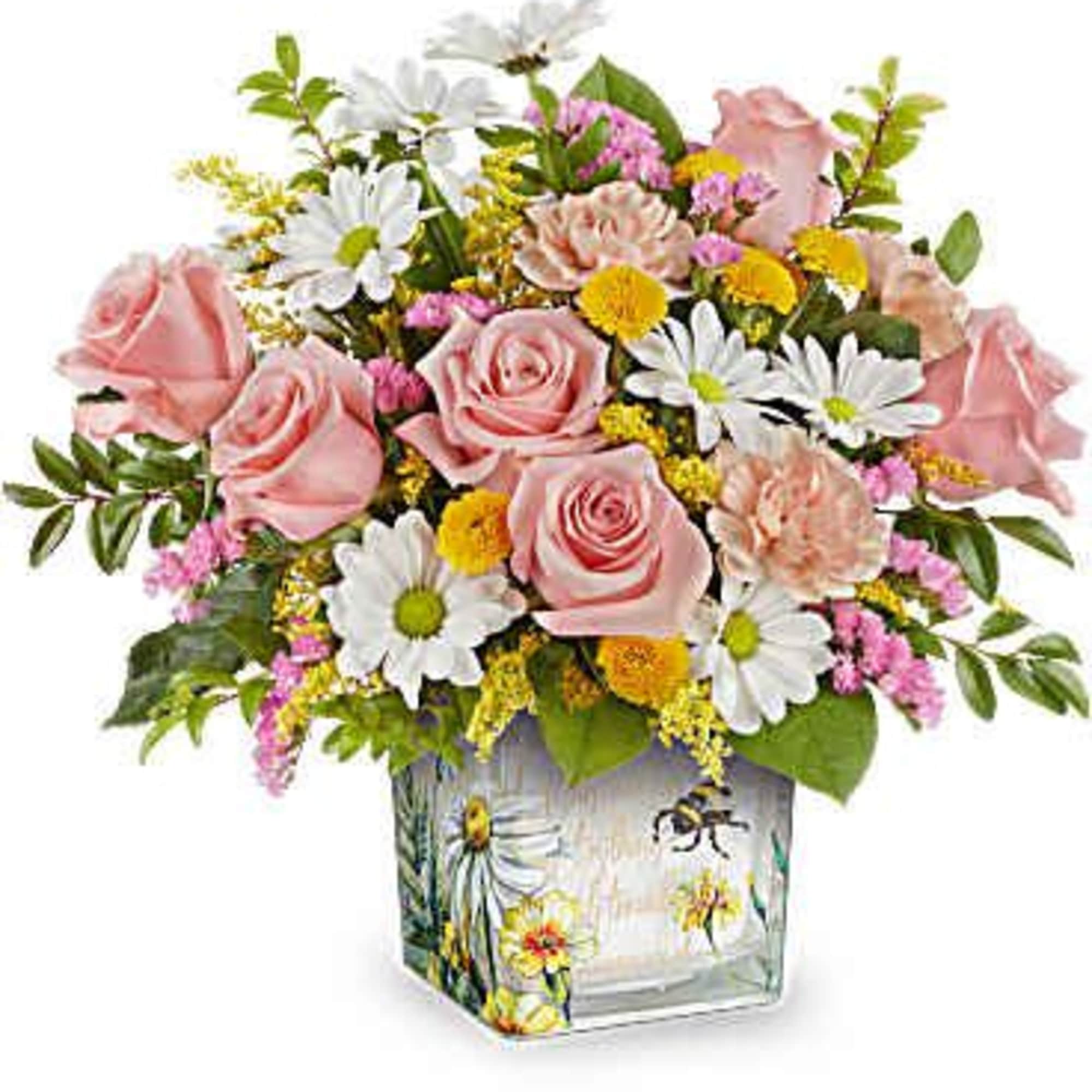Pink roses and daisies arranged in a square glass vase