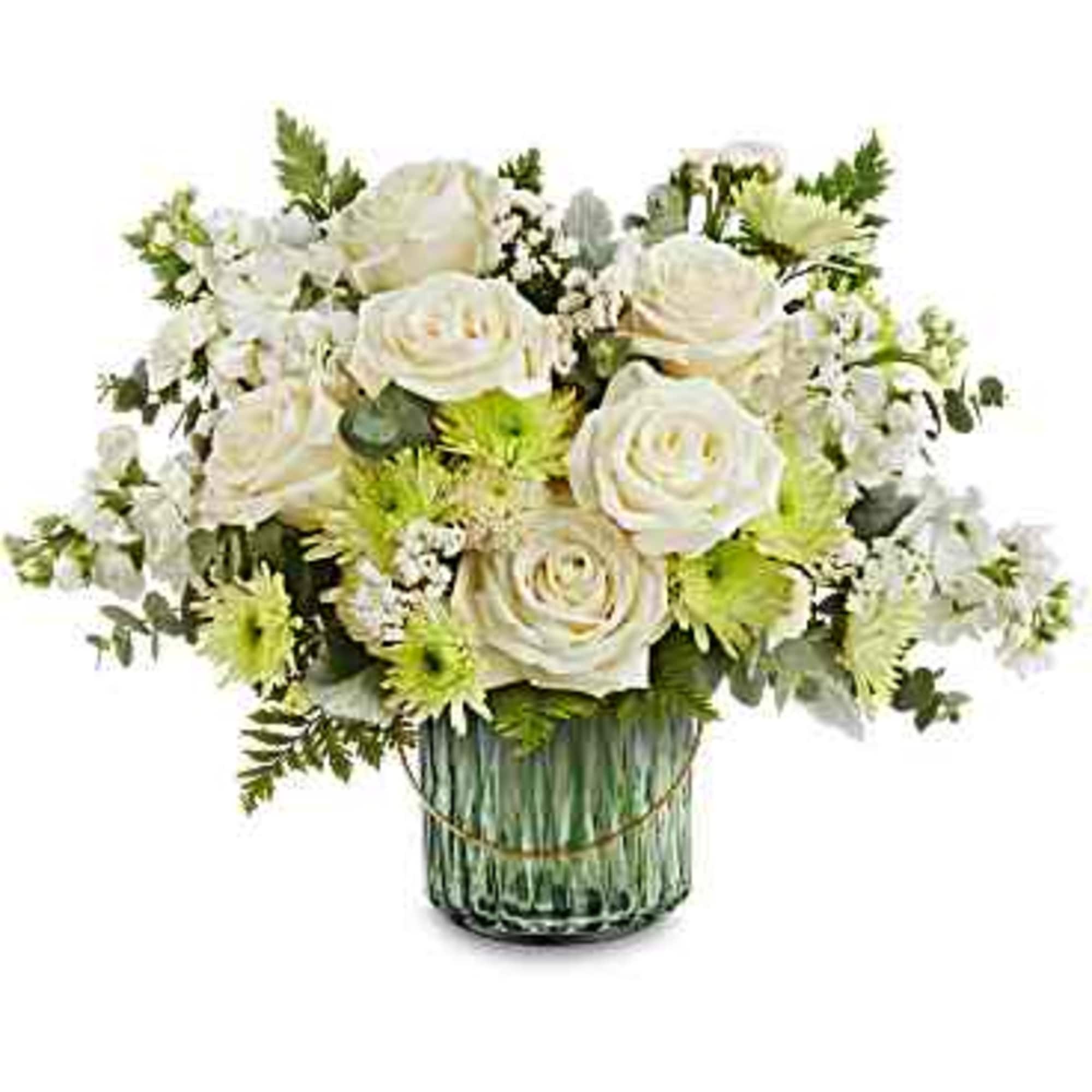White roses and small white flowers in a green glass vase