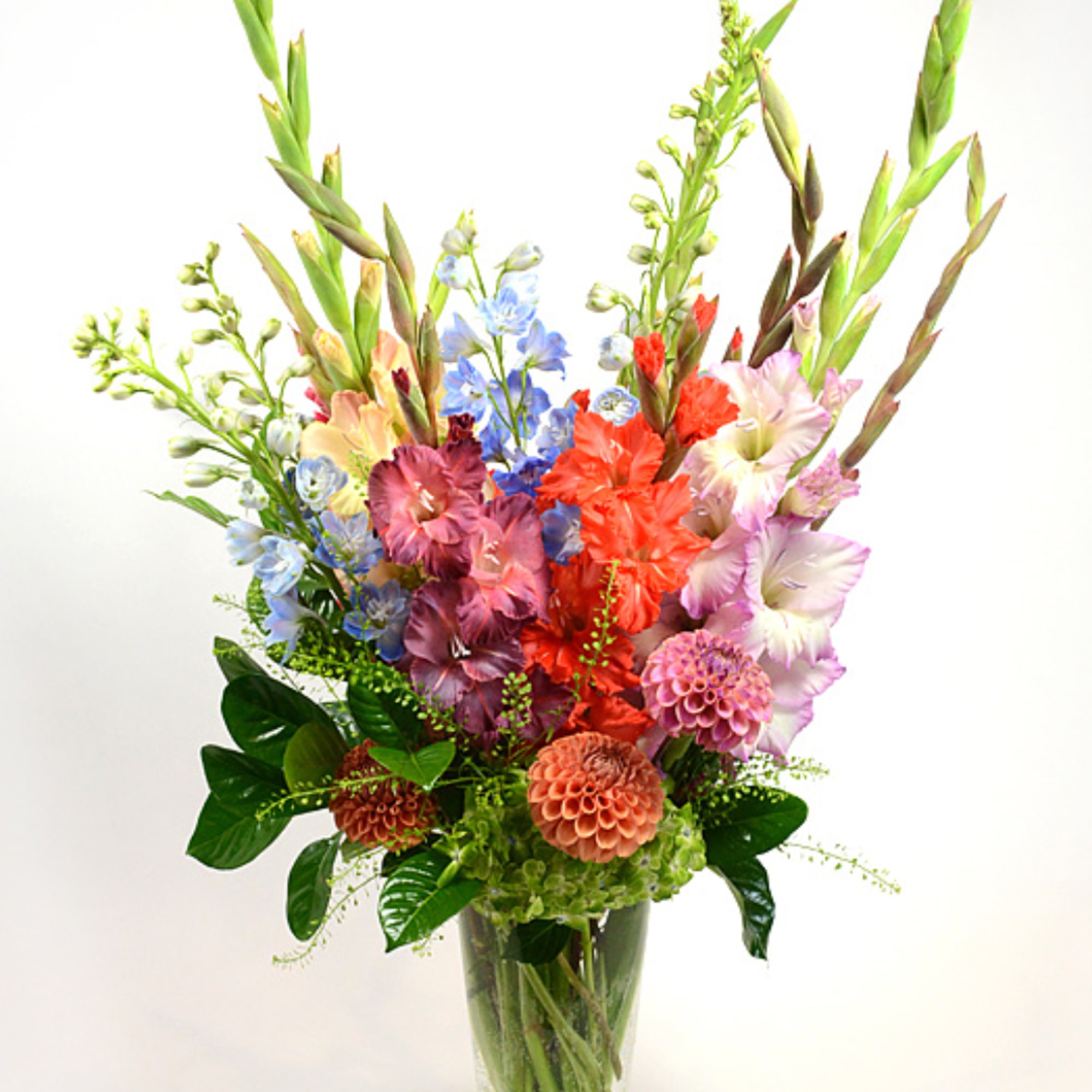 Tall mixed bouquet in a clear glass vase with colorful blooms