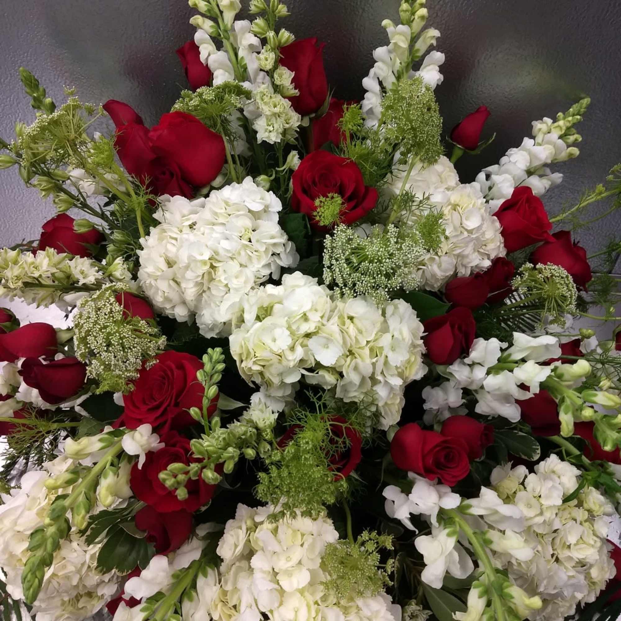 Red roses and white hydrangeas with white snapdragons in a large arrangement